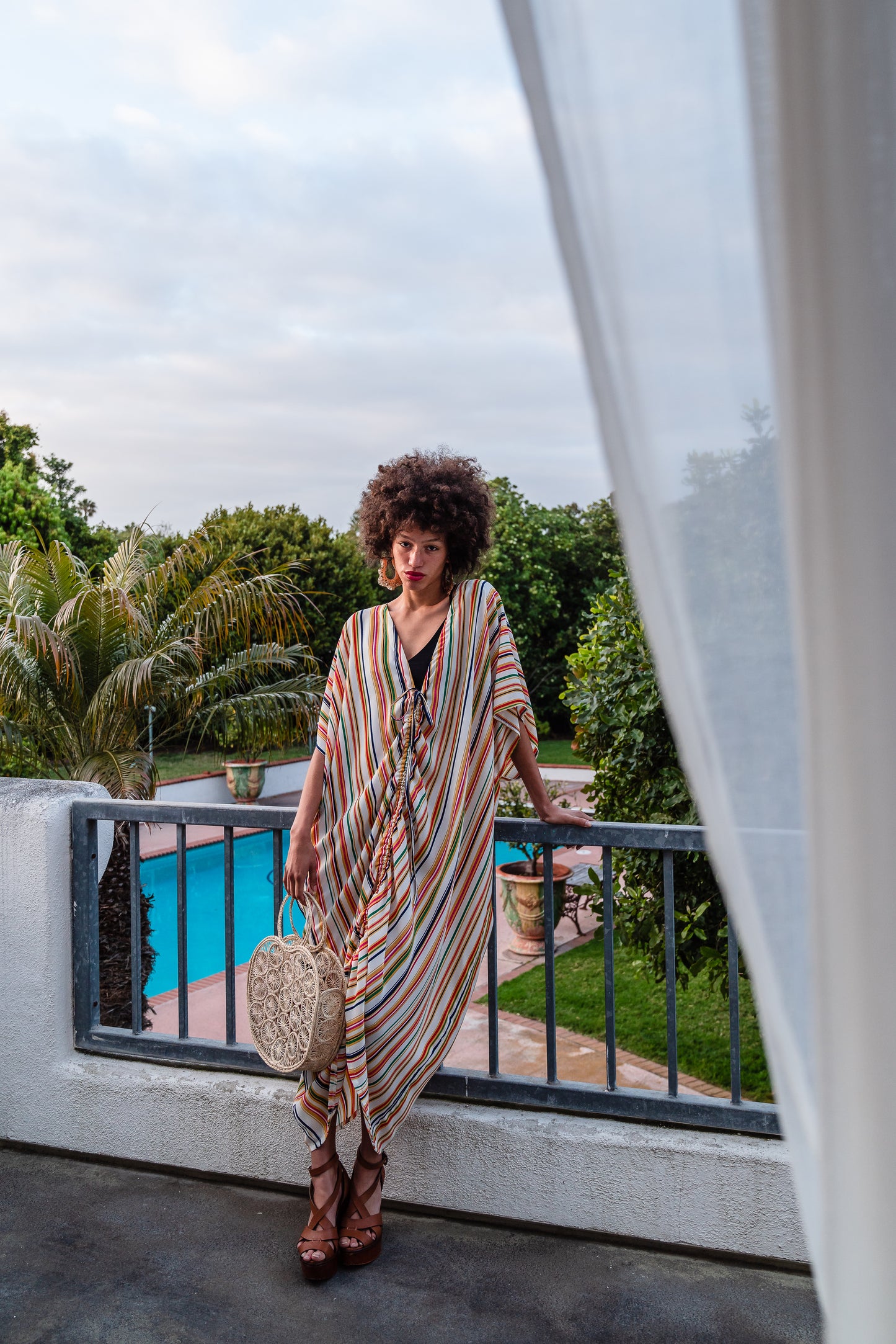 Multicolor vertical stripes on ivory chiffon caftan. This piece features a deep v-neck, batwing sleeve, a center drawstring for ruche styling, and ankle length hem. Retro bohemian aesthetic.