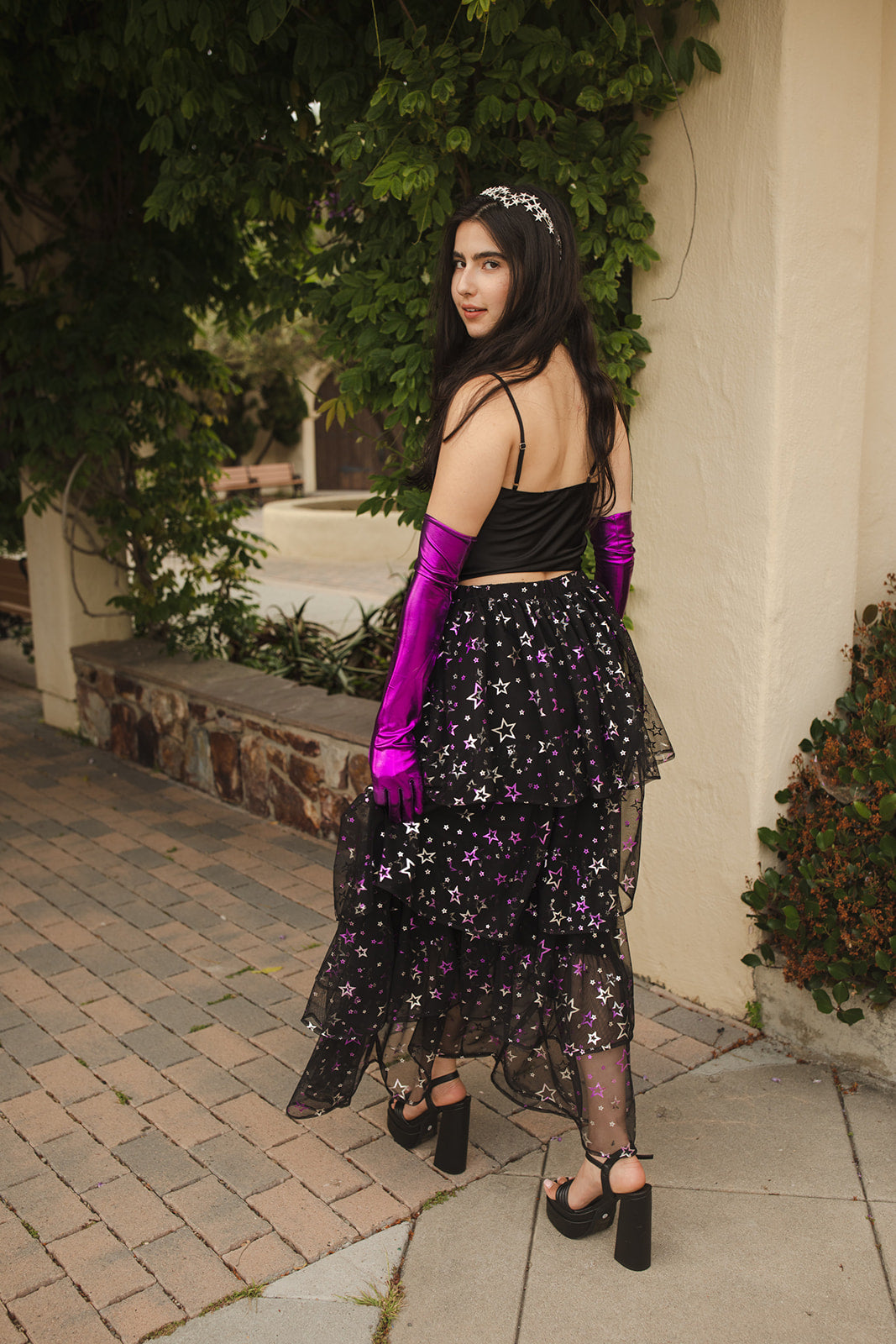 A tiered maxi skirt. Crafted with four tiers of layered black and metallic silver/purple stars and an elastic waist for all-day comfort. High waist with ankle hem.