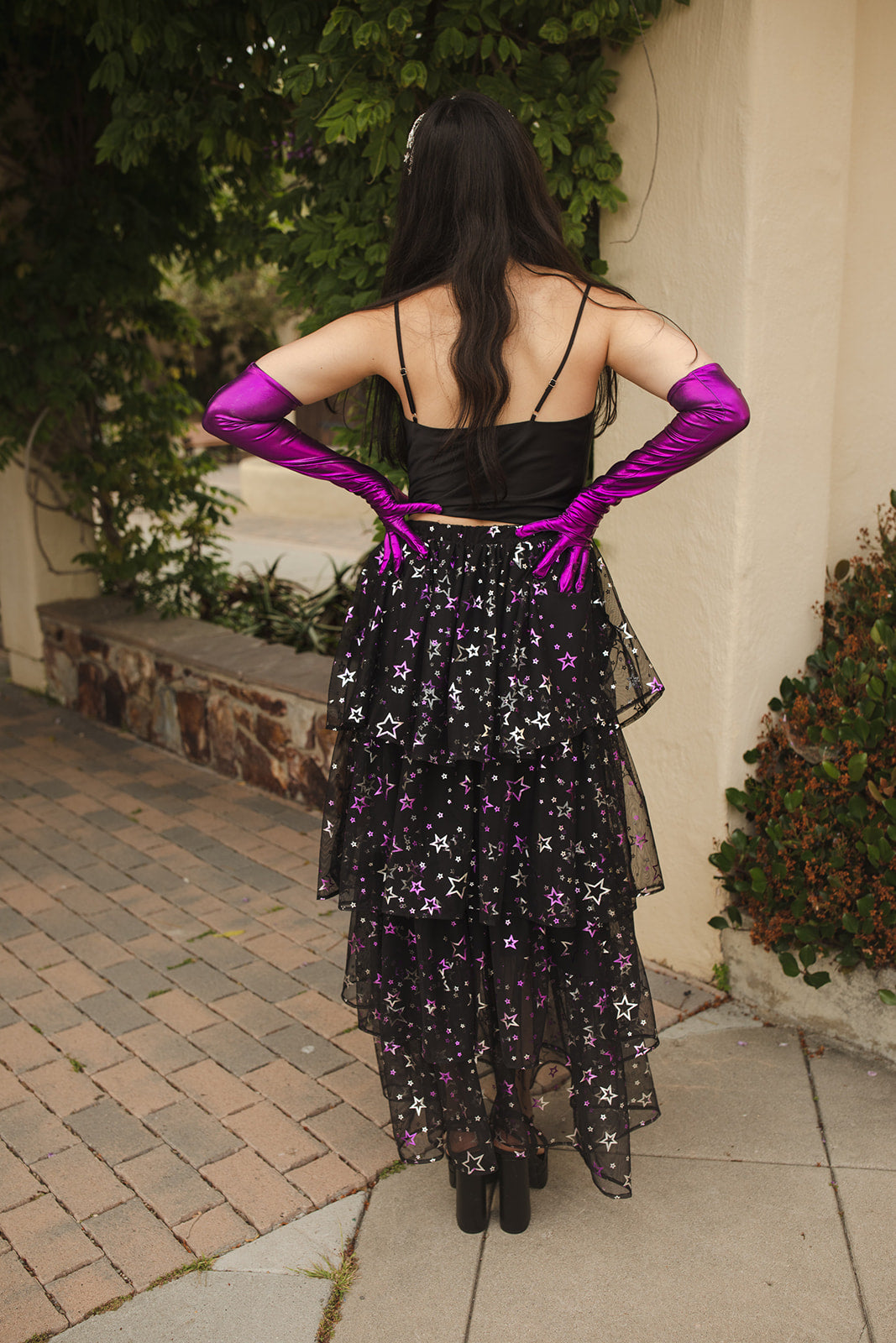 A tiered maxi skirt. Crafted with four tiers of layered black and metallic silver/purple stars and an elastic waist for all-day comfort. High waist with ankle hem.