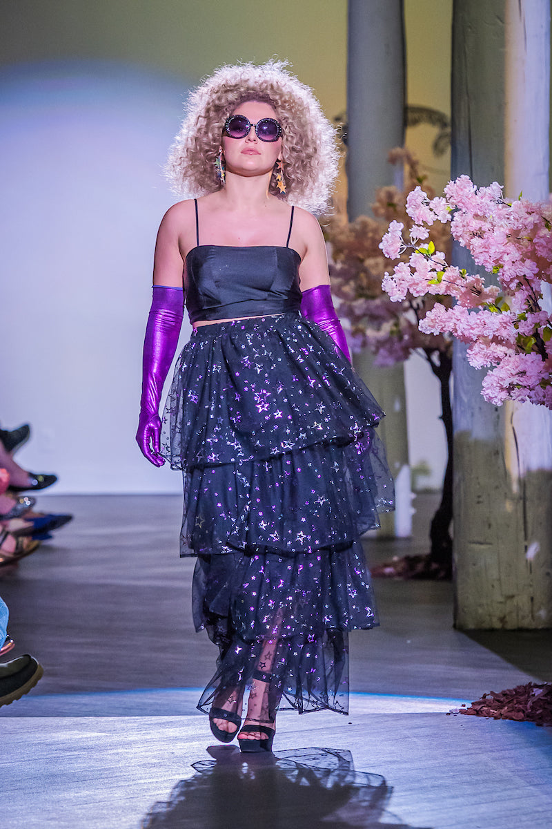 A tiered maxi skirt. Crafted with four tiers of layered black and metallic silver/purple stars and an elastic waist for all-day comfort. High waist with ankle hem.