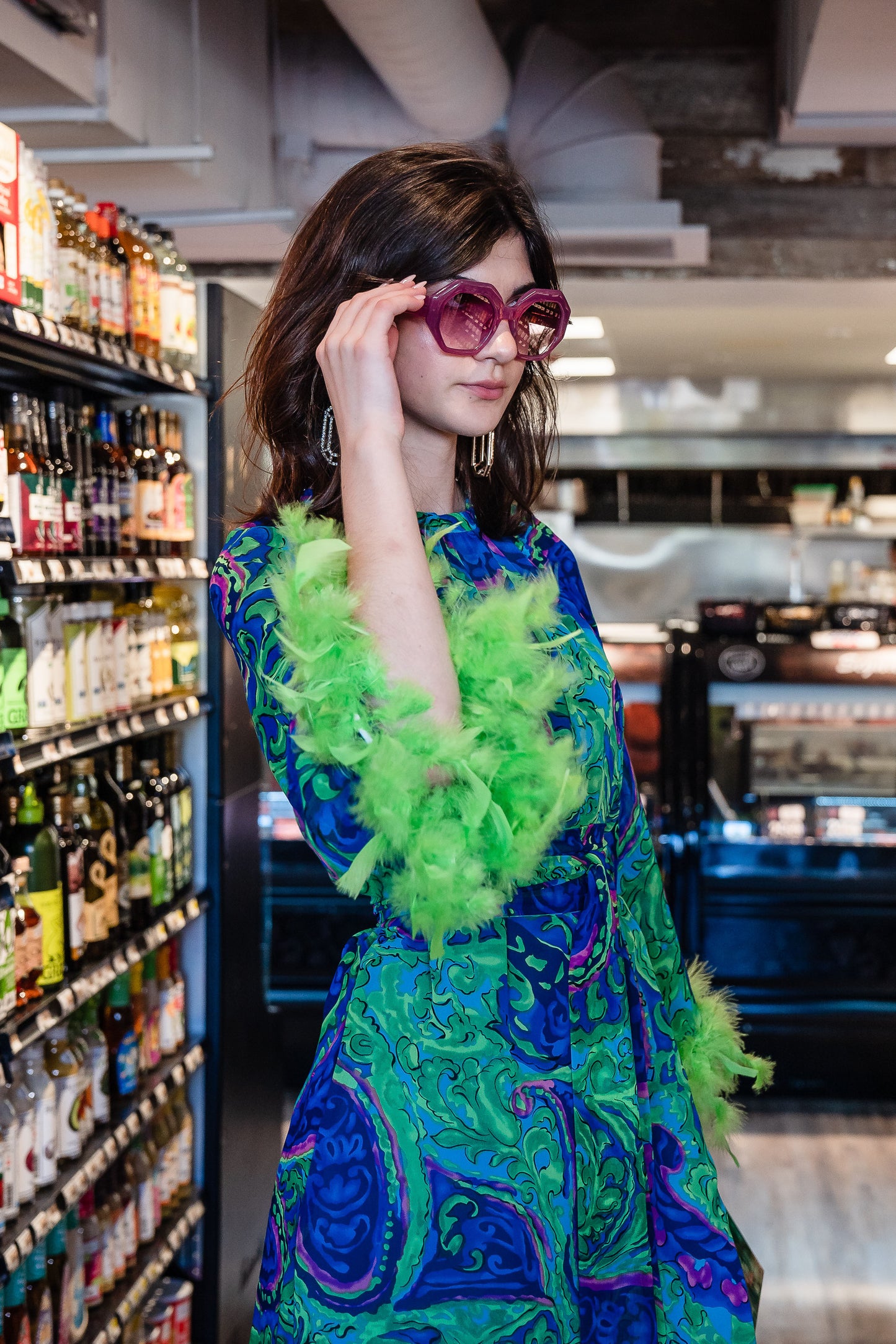 Funky fresh retro midi dress with royal blue and lime green abstract filigree swirl print with hints of aqua and fuchsia. The dress features a crew neck, keyhole detail at upper back, 3/4 bell sleeves with neon green feathers at cuff, a knee-length hem, and optional wrap tie for a cinched waist.