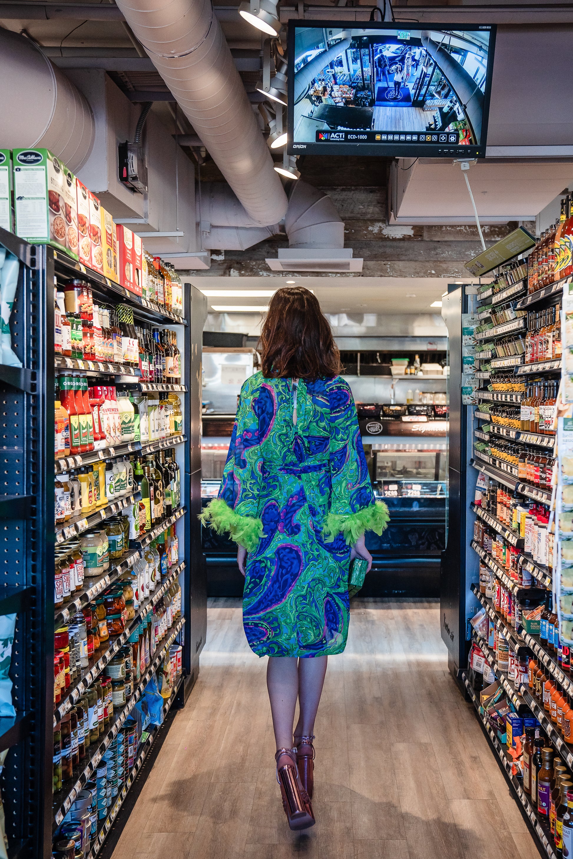 Funky fresh retro midi dress with royal blue and lime green abstract filigree swirl print with hints of aqua and fuchsia. The dress features a crew neck, keyhole detail at upper back, 3/4 bell sleeves with neon green feathers at cuff, a knee-length hem, and optional wrap tie for a cinched waist.