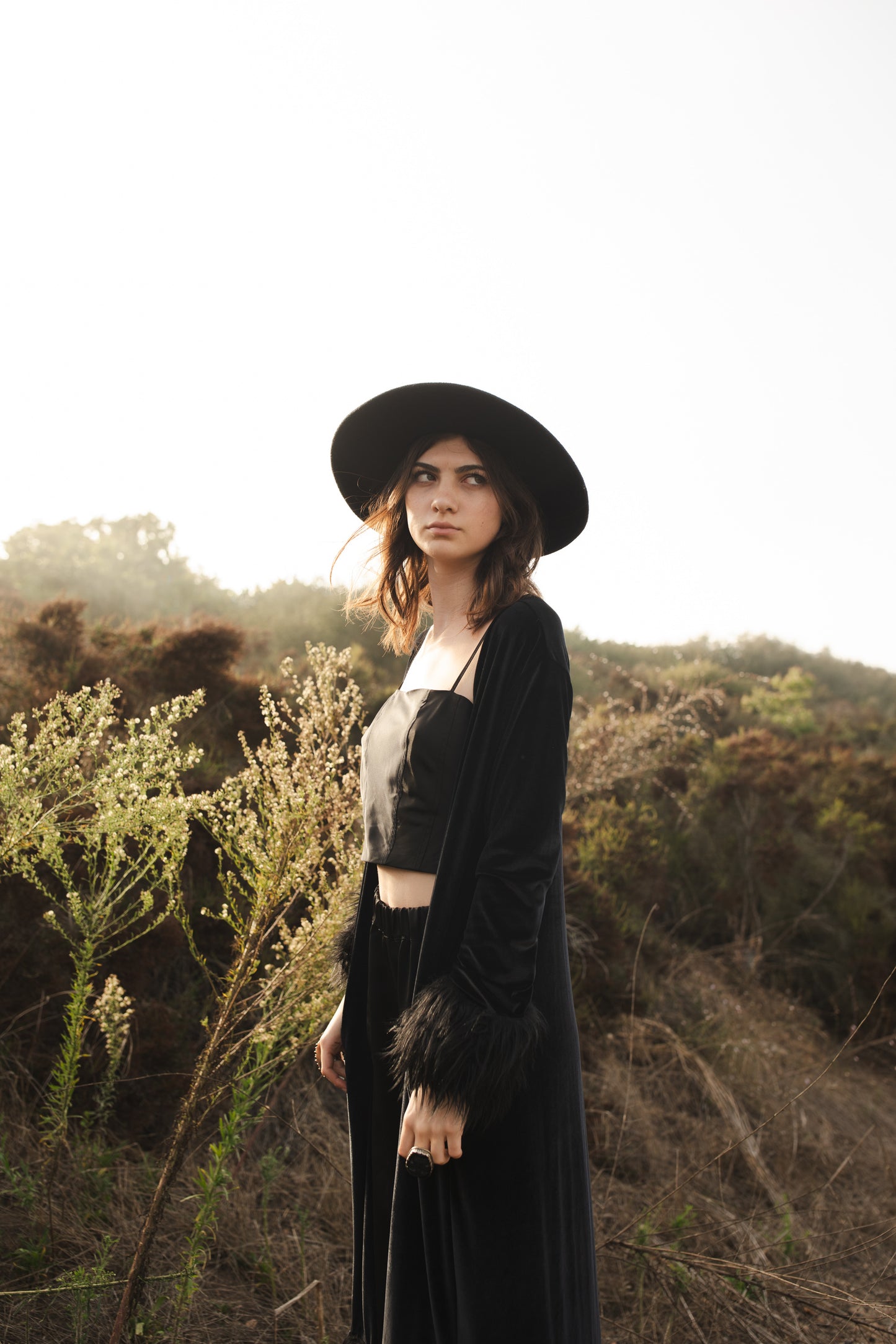 This luscious floor length Jennafer Grace coat is made with a black stretch velvet fabric featuring black faux fur cuffs at end of sleeves and base hem. It also features in-seam pockets and a super soft bamboo jersey lining. Designed and crafted in southern California.