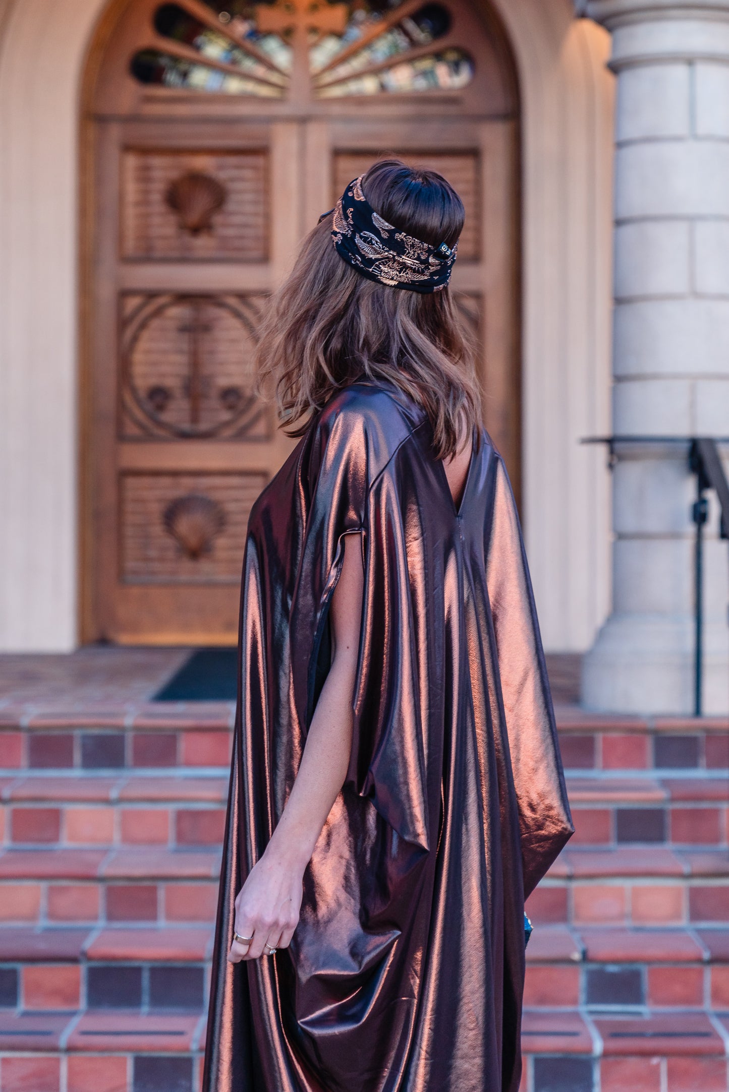 This copper caftan offers a sleek and shimmering look that exudes boldness and luxury made from a generous amount of metallic coated poly/spandex jersey.