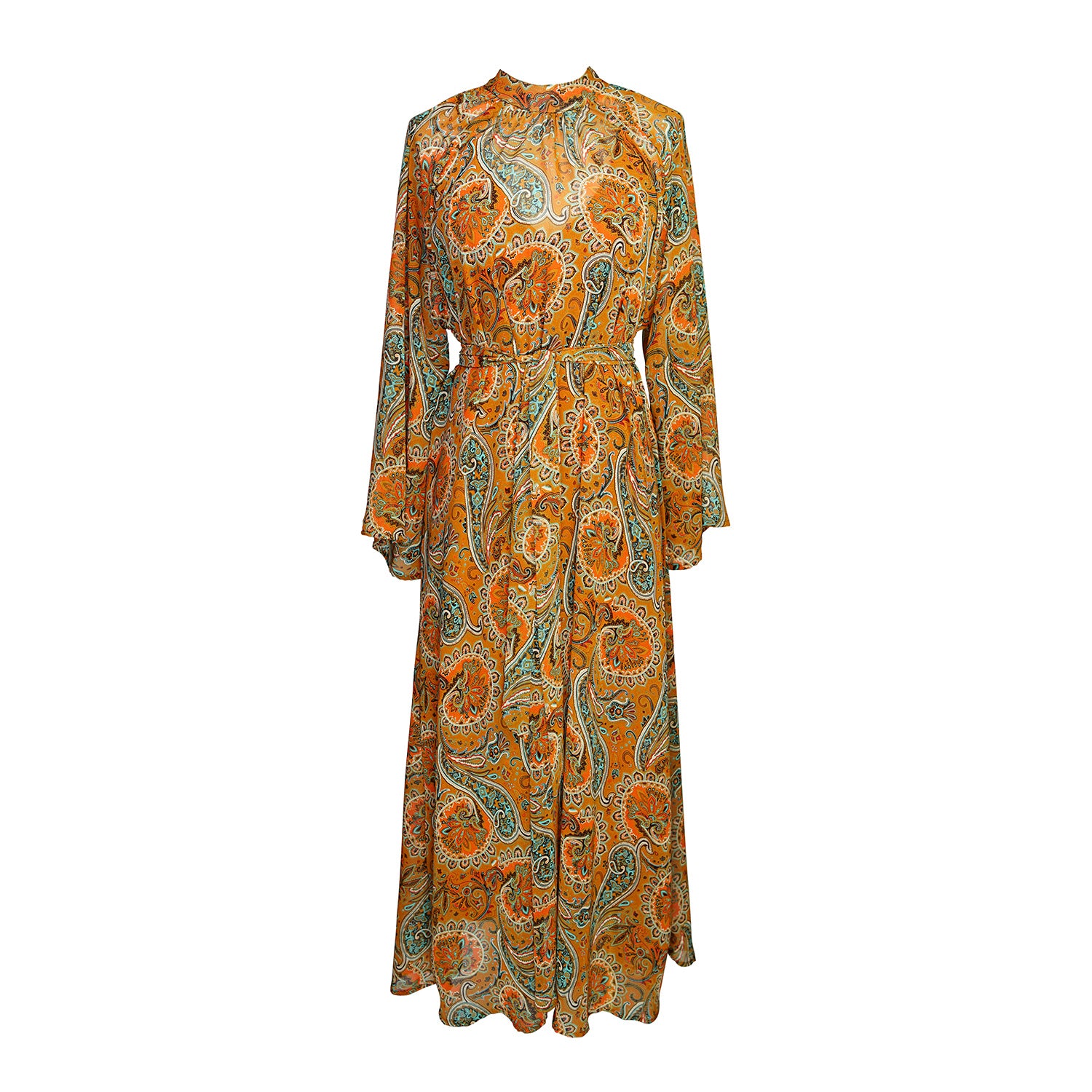 Model wears a soft chiffon midi length dress in caramel brown with turquoise, green and orange paisley print. The sleeves are bell shaped and the dress has a wrap around belt