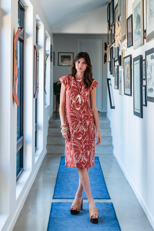 Knee length sleeveless shift dress, in a rust and taupe abstract, marble like pattern, the dress has shoulder pads.