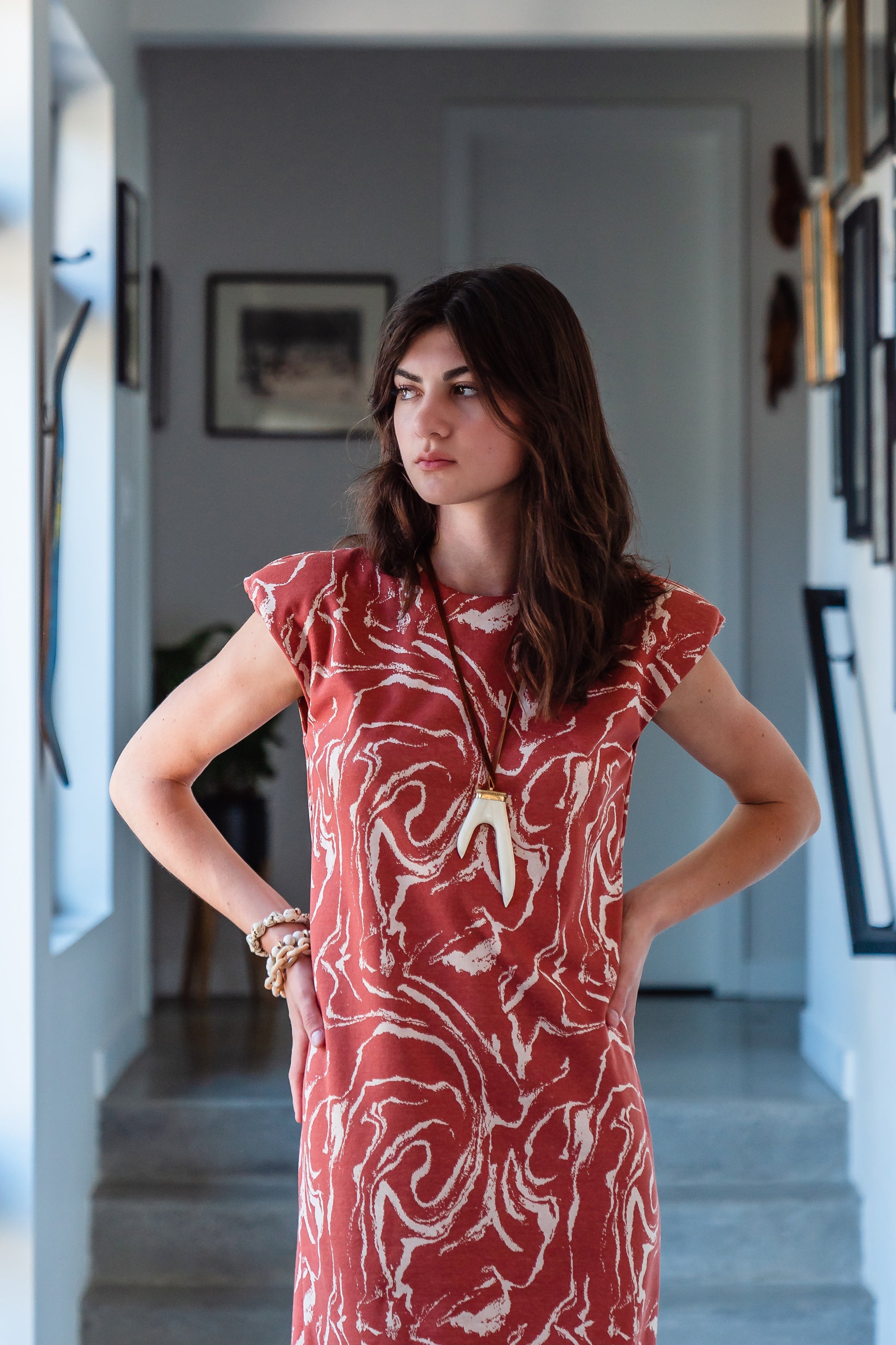 Knee length sleeveless shift dress, in a rust and taupe abstract, marble like pattern, the dress has shoulder pads.