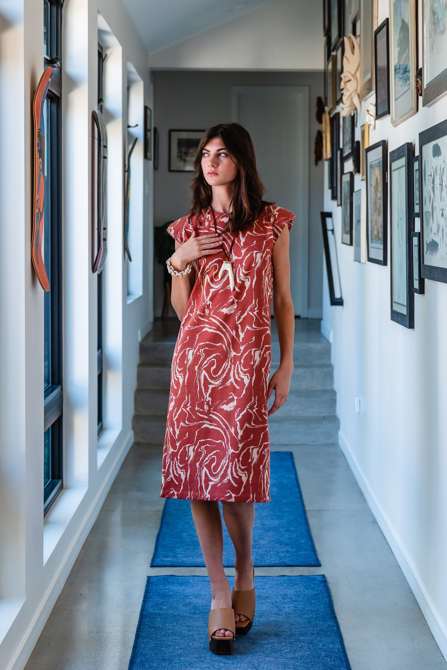Knee length sleeveless shift dress, in a rust and taupe abstract, marble like pattern, the dress has shoulder pads.