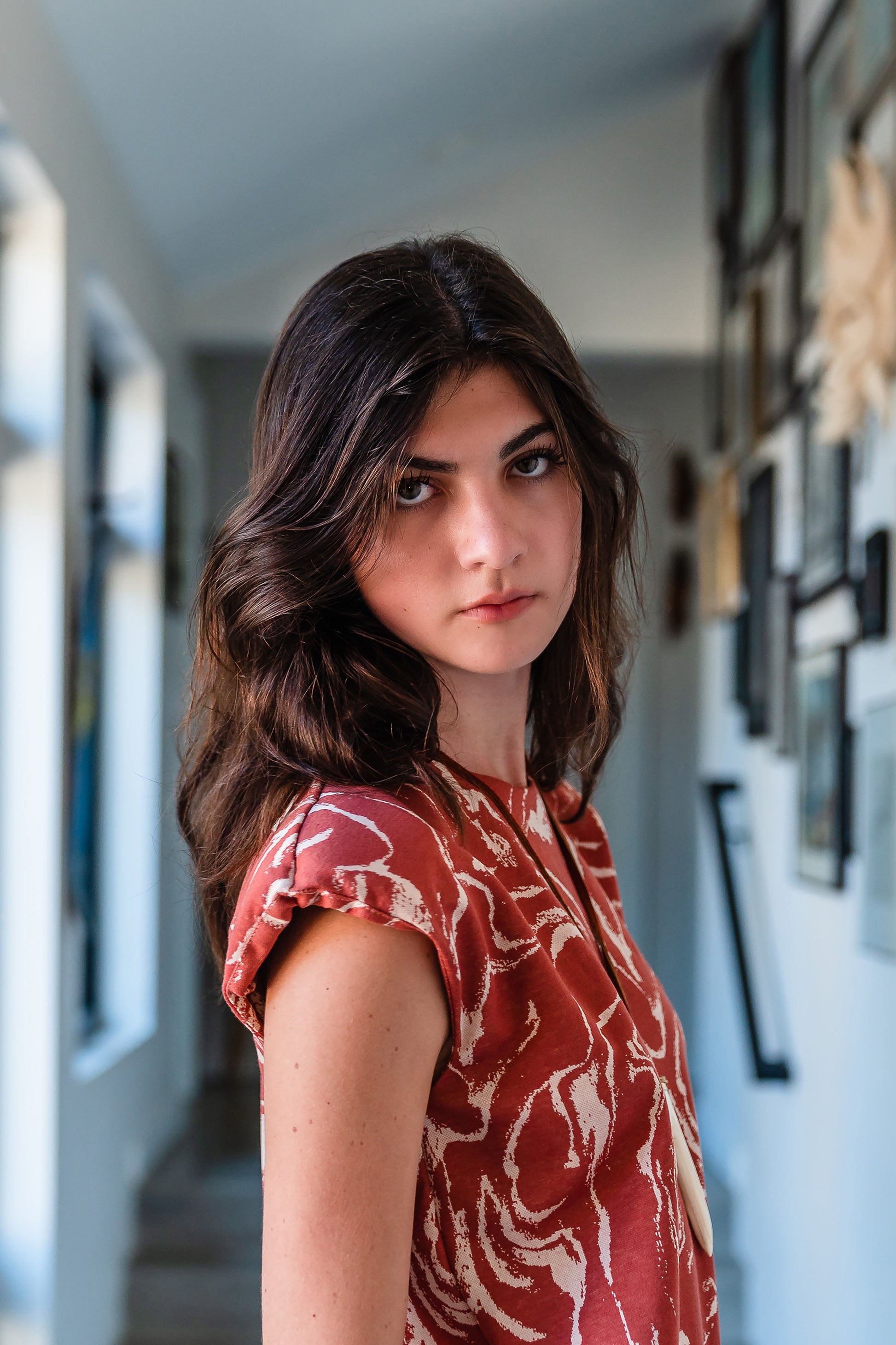 Knee length sleeveless shift dress, in a rust and taupe abstract, marble like pattern, the dress has shoulder pads.