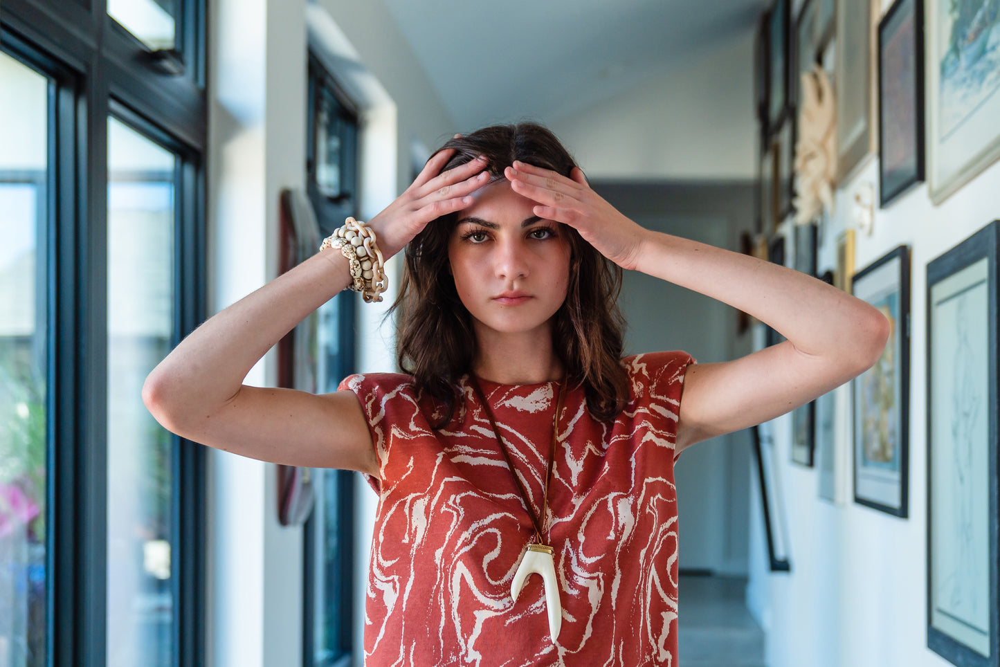 Knee length sleeveless shift dress, in a rust and taupe abstract, marble like pattern, the dress has shoulder pads.