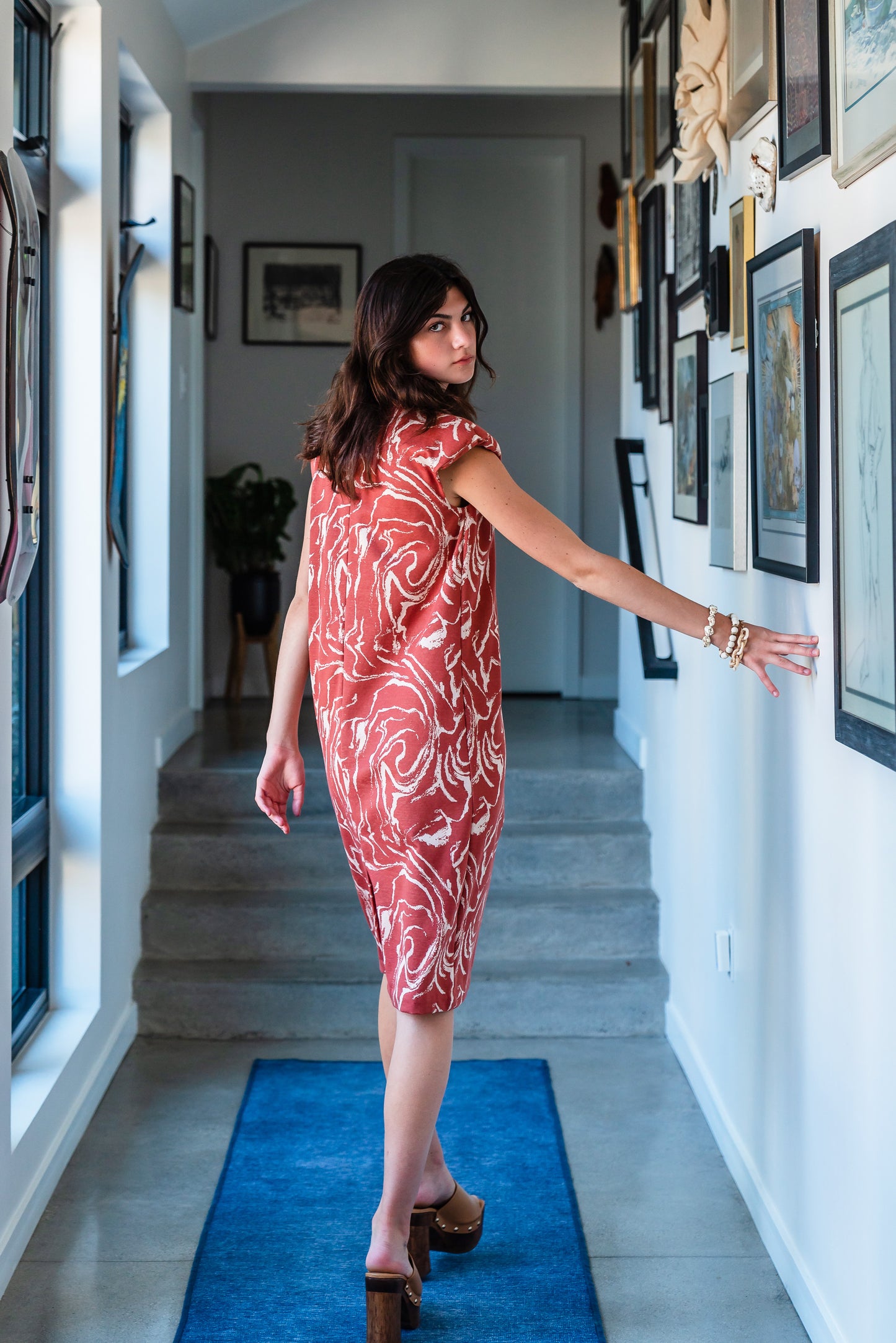 Knee length sleeveless shift dress, in a rust and taupe abstract, marble like pattern, the dress has shoulder pads.