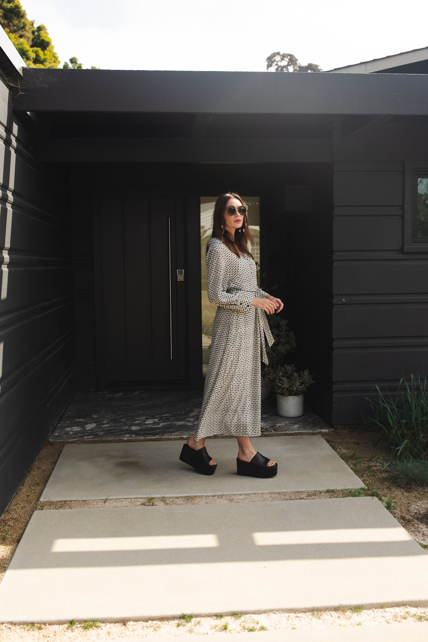 This black and white maxi dress is sophisticated yet effortless with its classic collar, v-neck design paired with long, cuffed sleeves, full-length skirt, and a slim matching sash.