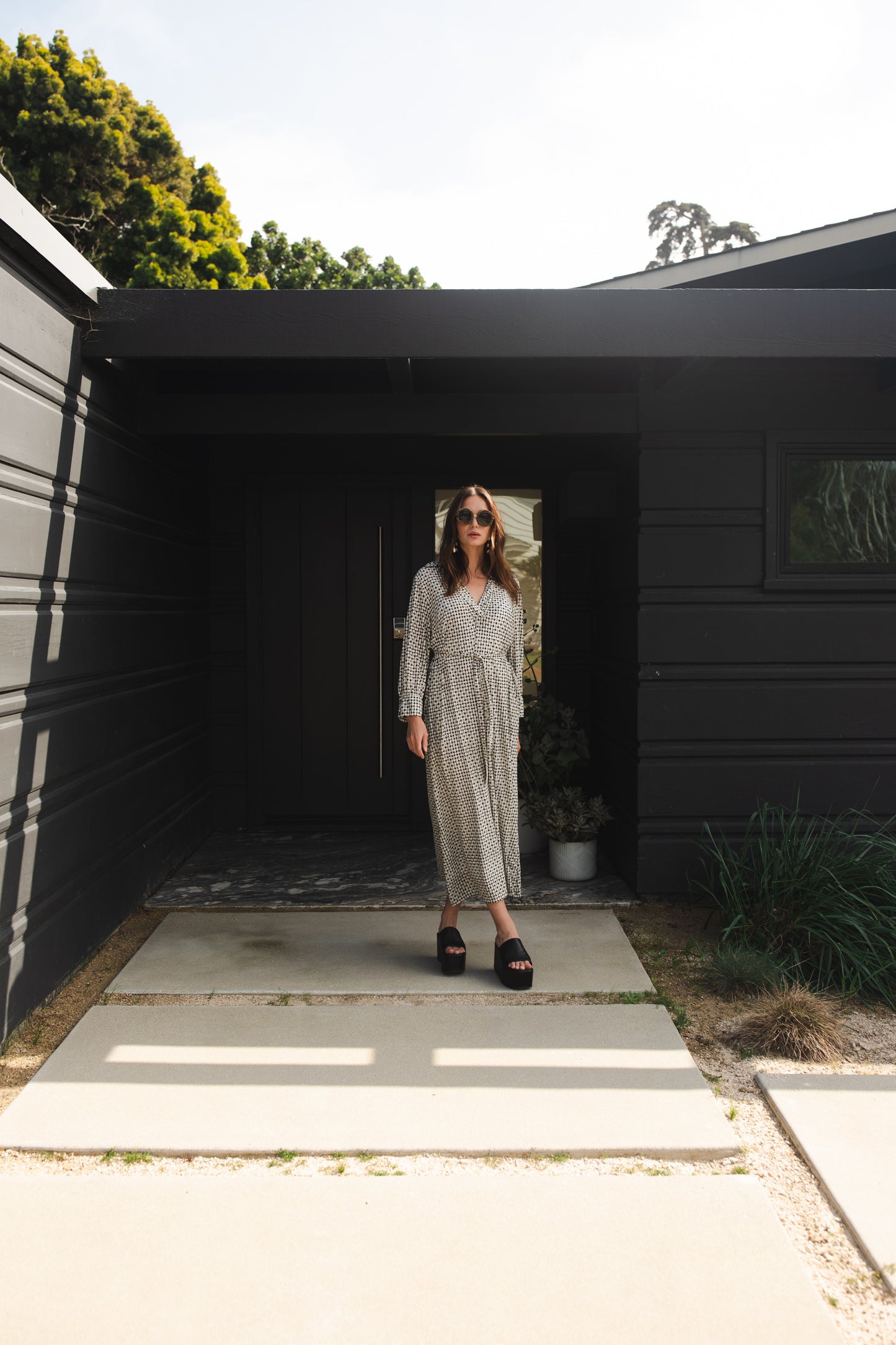 This black and white maxi dress is sophisticated yet effortless with its classic collar, v-neck design paired with long, cuffed sleeves, full-length skirt, and a slim matching sash.