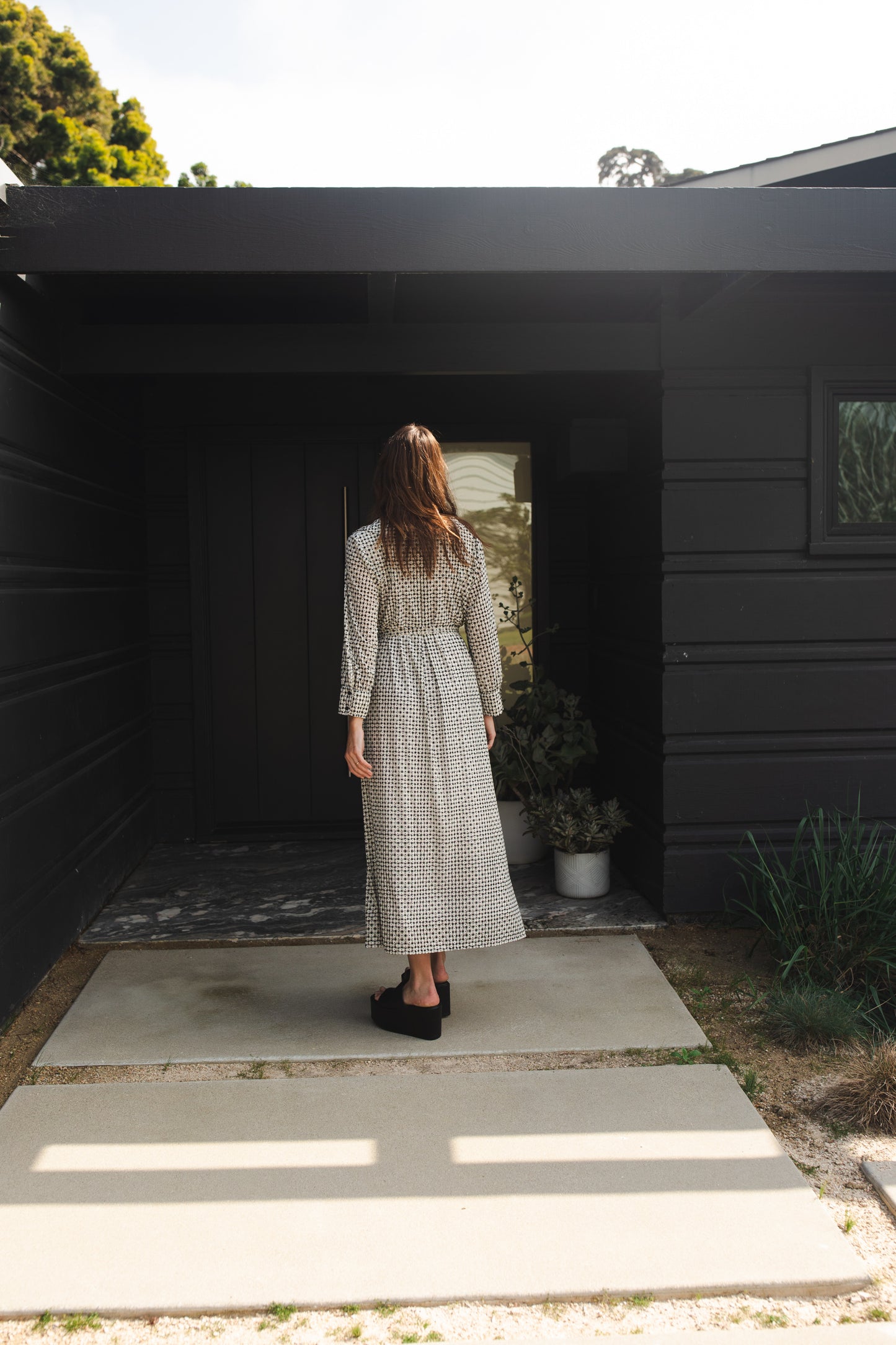 This black and white maxi dress is sophisticated yet effortless with its classic collar, v-neck design paired with long, cuffed sleeves, full-length skirt, and a slim matching sash.