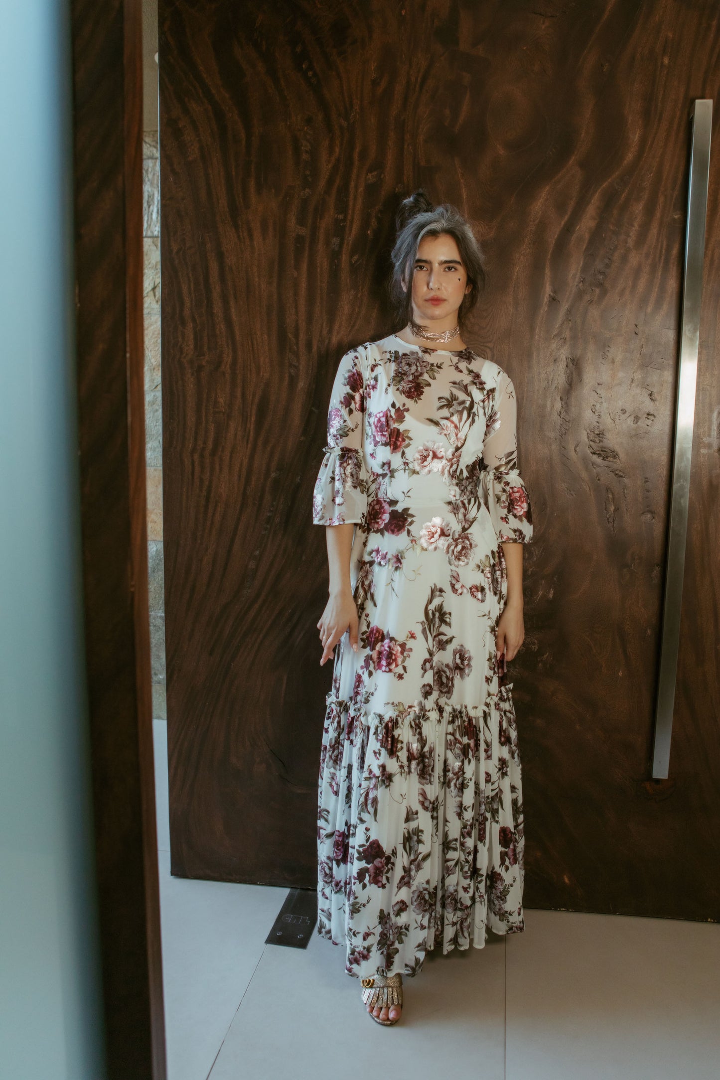 An airy ruffled maxi dress. Made with an airy and metallic detail floral mesh fabric featuring pockets, mid-length bell sleeves, and a full, single-tiered skirt with ankle hem. Includes a matching slip dress that can be worn on its own.