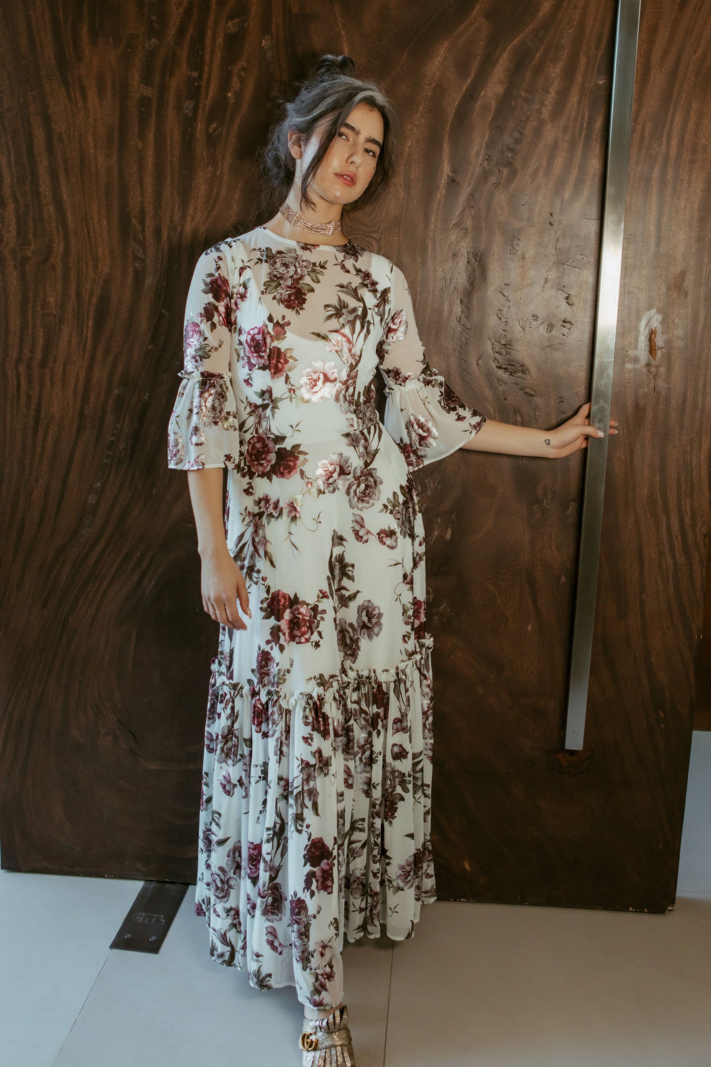 An airy ruffled maxi dress. Made with an airy and metallic detail floral mesh fabric featuring pockets, mid-length bell sleeves, and a full, single-tiered skirt with ankle hem. Includes a matching slip dress that can be worn on its own.