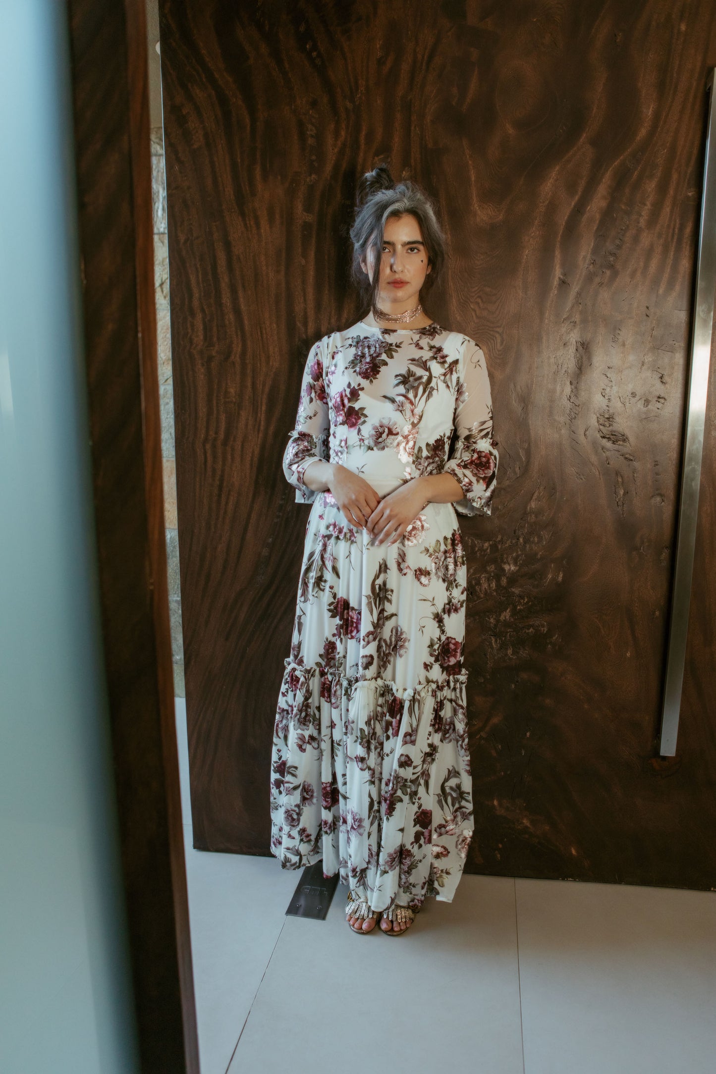 An airy ruffled maxi dress. Made with an airy and metallic detail floral mesh fabric featuring pockets, mid-length bell sleeves, and a full, single-tiered skirt with ankle hem. Includes a matching slip dress that can be worn on its own.