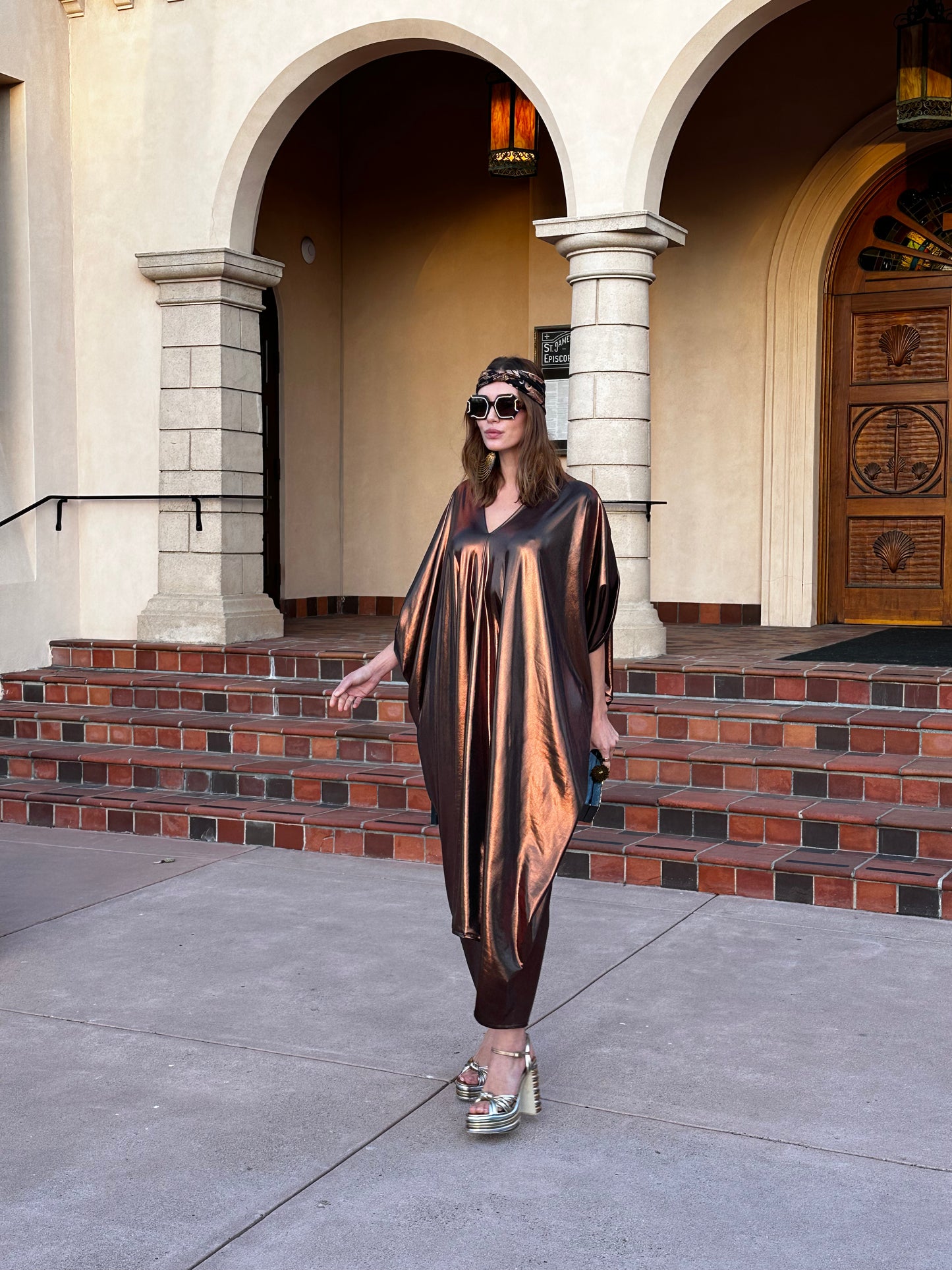 This copper caftan offers a sleek and shimmering look that exudes boldness and luxury made from a generous amount of metallic coated poly/spandex jersey.