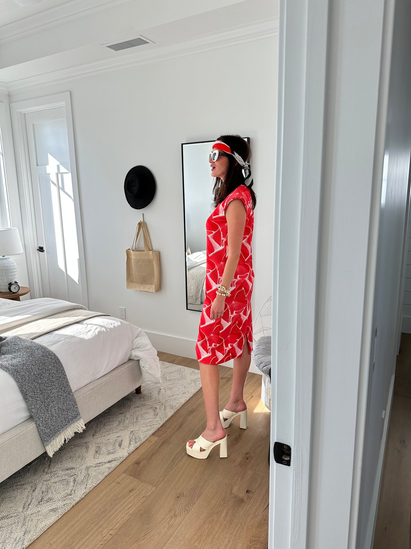 Model wears white shift dress with graphic red print! There are shoulder pads to add dimension and the dress had a back slit.