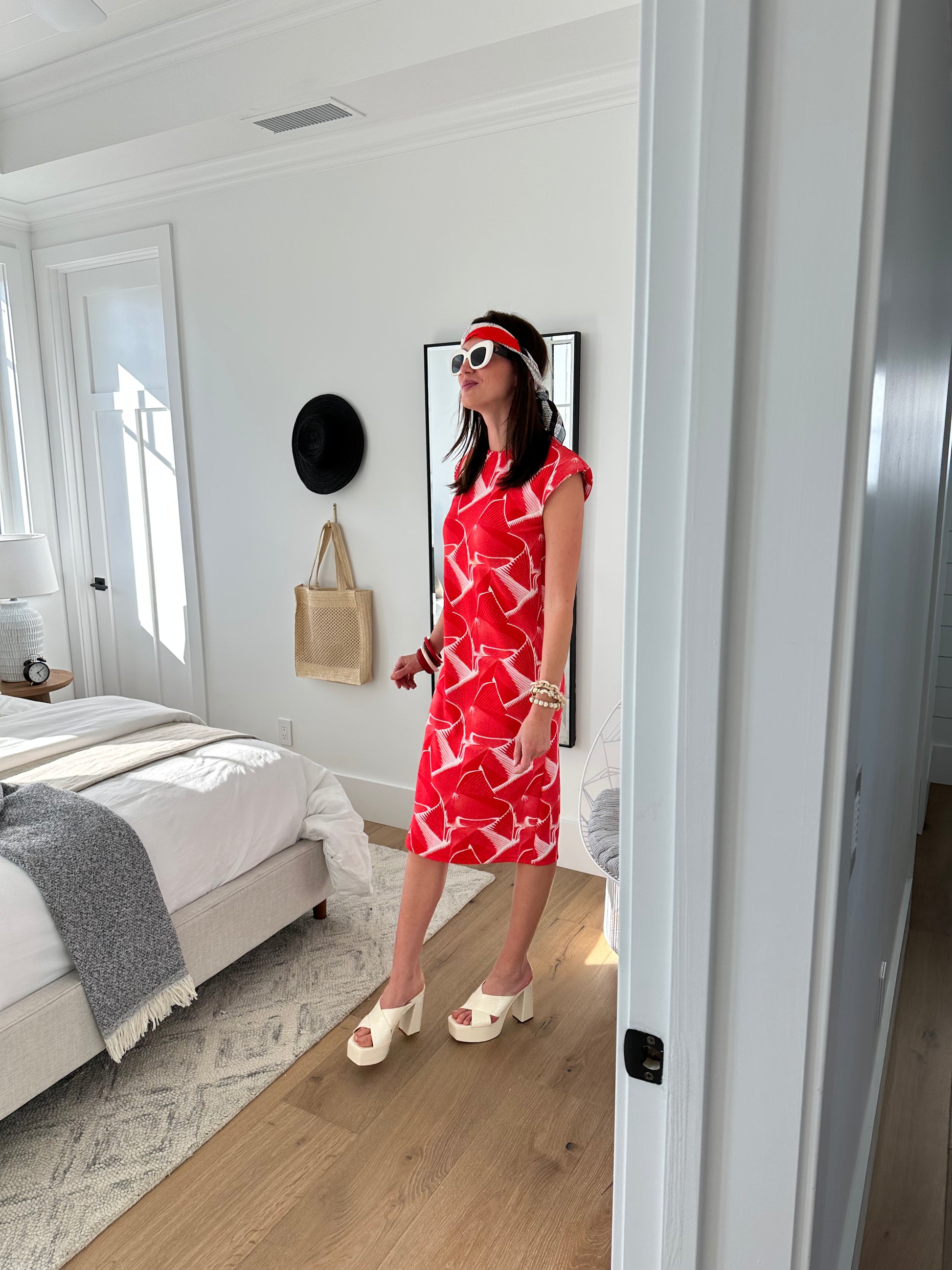 Model wears white shift dress with graphic red print! There are shoulder pads to add dimension and the dress had a back slit.