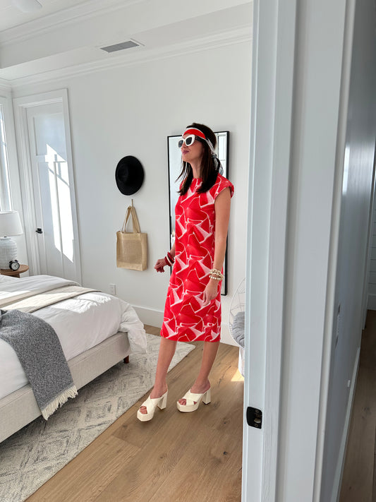 Model wears white shift dress with graphic red print! There are shoulder pads to add dimension and the dress had a back slit.