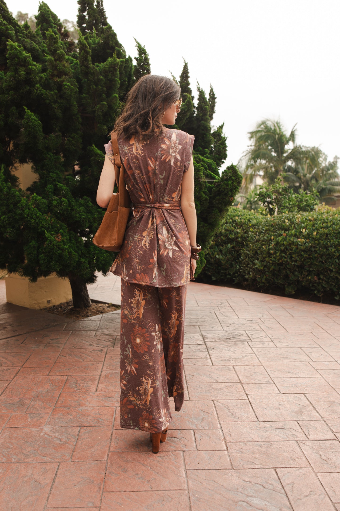 Tunic top and palazzo pant set made from a luxe jersey. Muted red base with orange floral print. Featuring tab sleeves, side slits and an extended obi-style belt on the top, and pockets, elastic waist and a soft hidden drawstring on the bottoms.