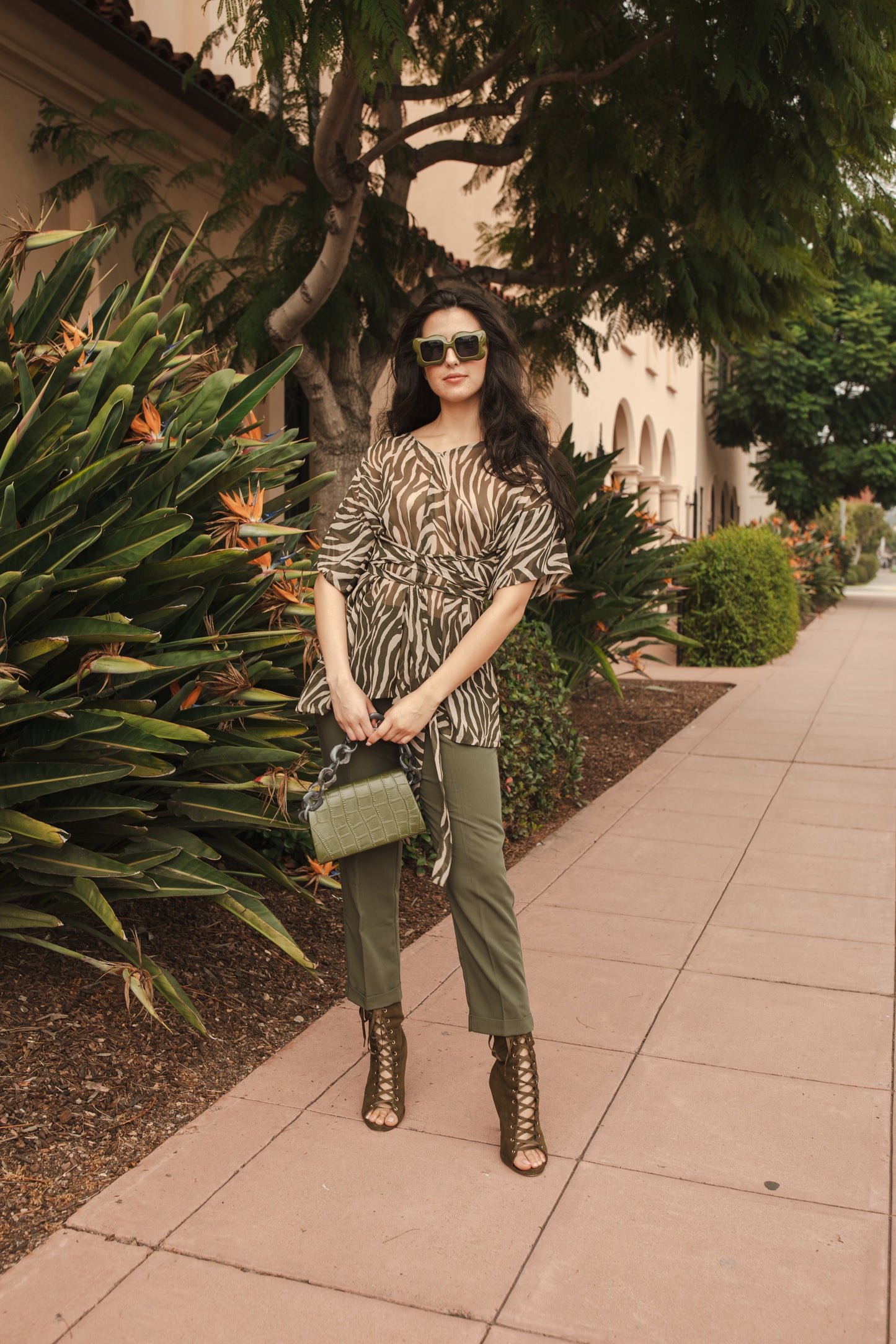 Tunic top with large flowy short sleeves and wide short v-neck. Featuring an olive green zebra print in semi-sheer chiffon with matching waist tie.