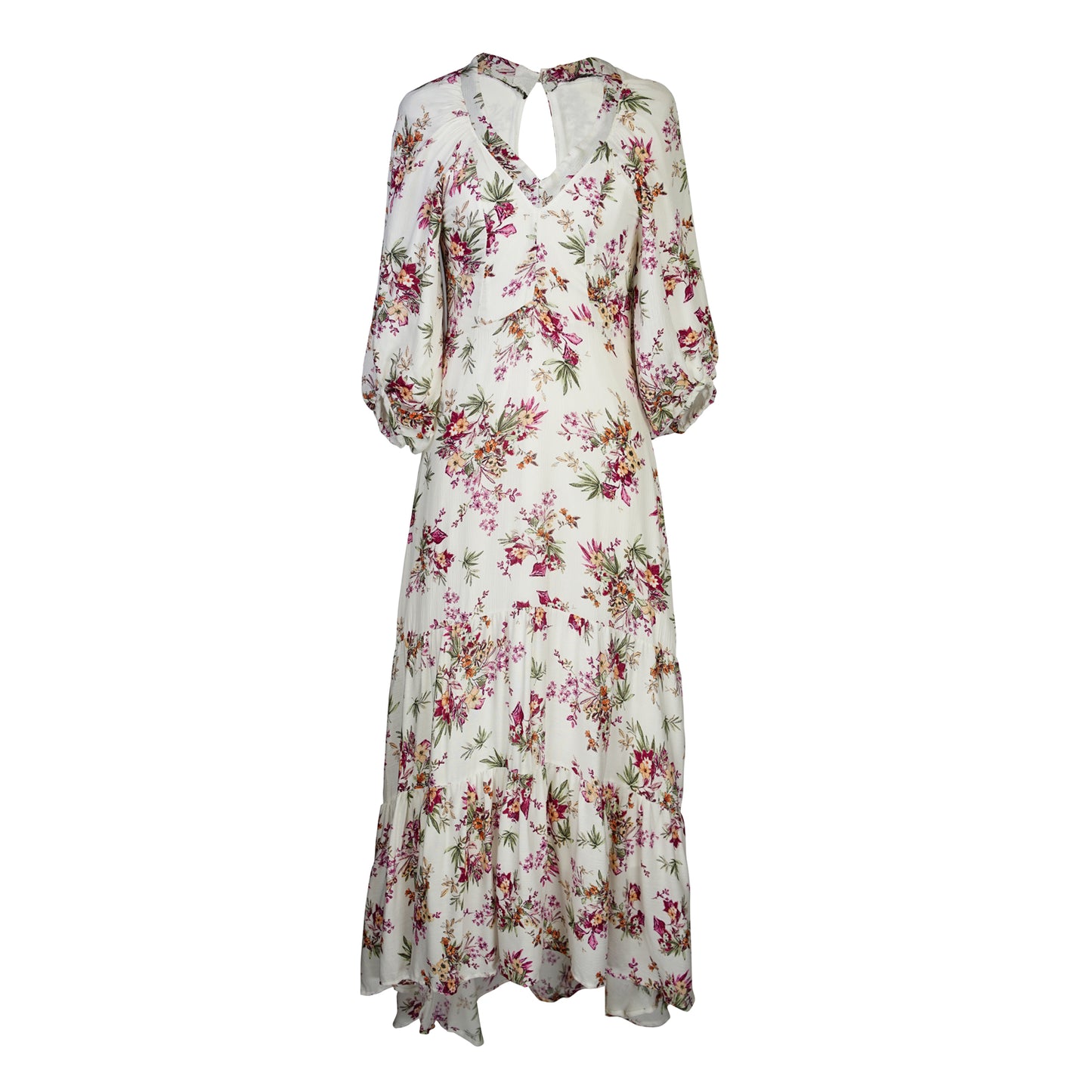 The Vana Vixen maxi dress by Jennafer Grace with a white base and summer floral print of deep pinks, yellows, and greens. Made from a linen like cotton rayon frabric, featuring a v-neck, detailed bishop sleeves, tiered ruffle skirt with ankle length hem, and a keyhole slit at back.