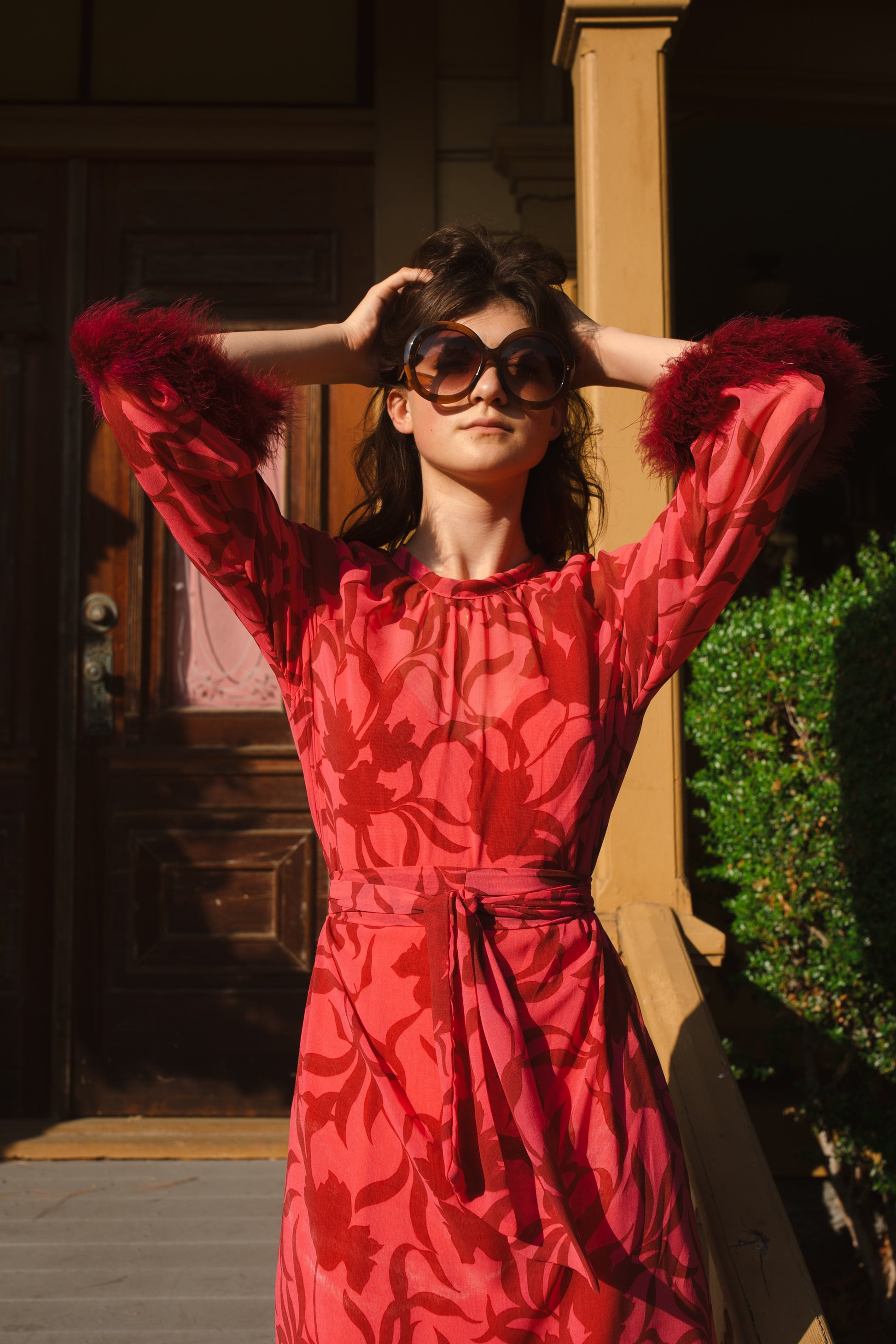 This sophisticated stunner has all the right details - generous bell sleeves with feather detail, flowing knee-length midi skirt, and a slim matching sash for a cinched waist.