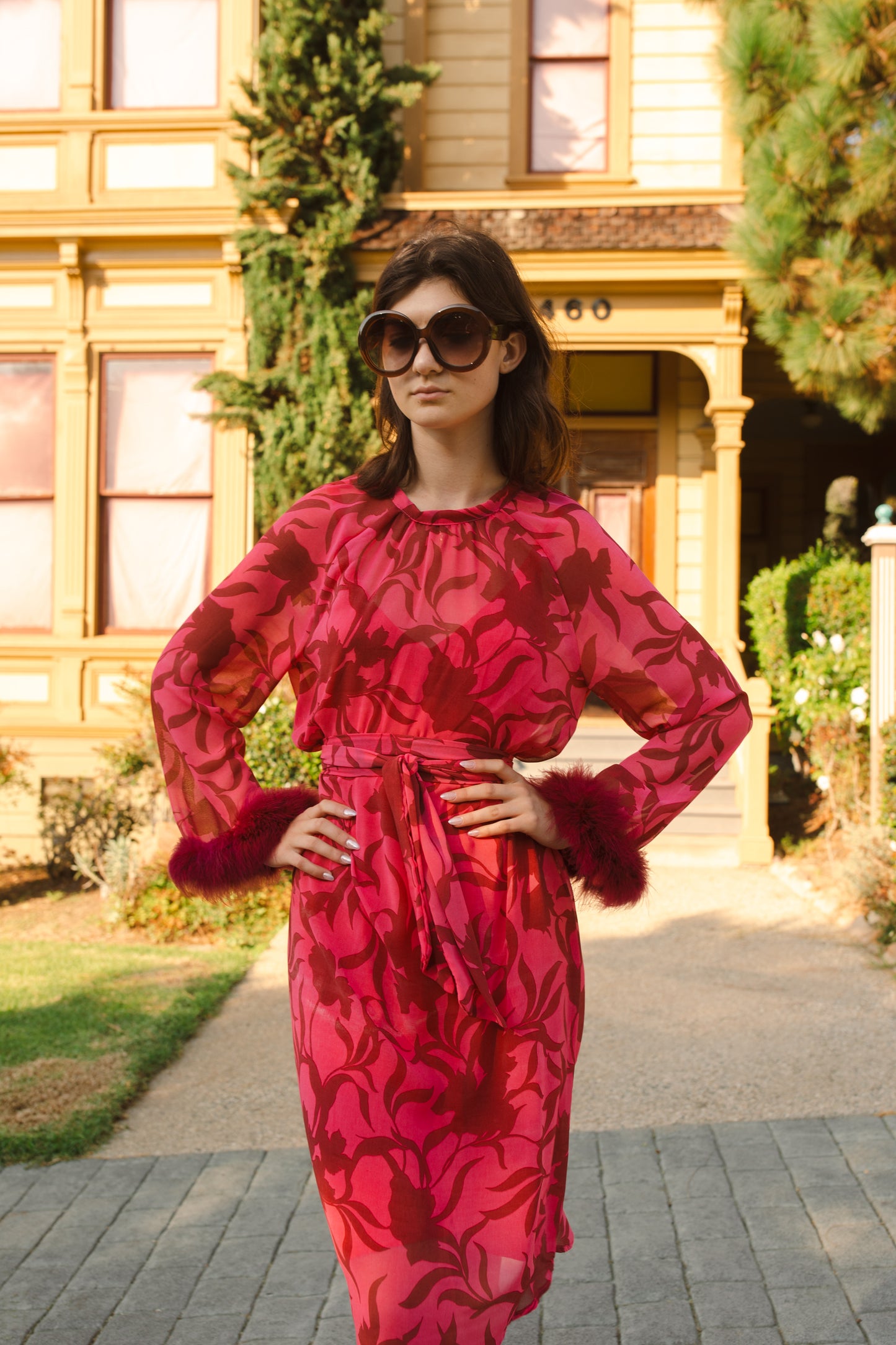 This sophisticated stunner has all the right details - generous bell sleeves with feather detail, flowing knee-length midi skirt, and a slim matching sash for a cinched waist.