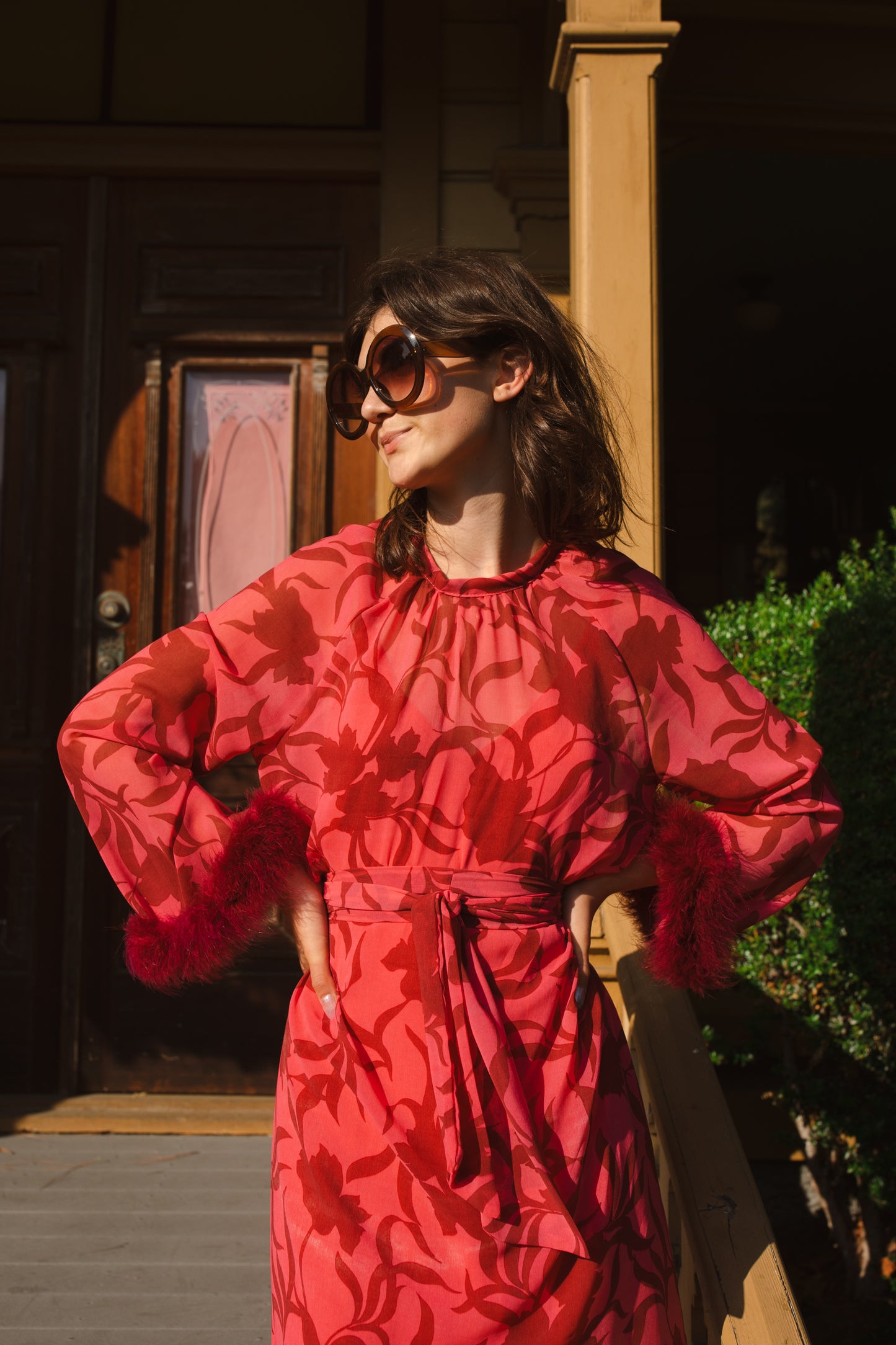 This sophisticated stunner has all the right details - generous bell sleeves with feather detail, flowing knee-length midi skirt, and a slim matching sash for a cinched waist.