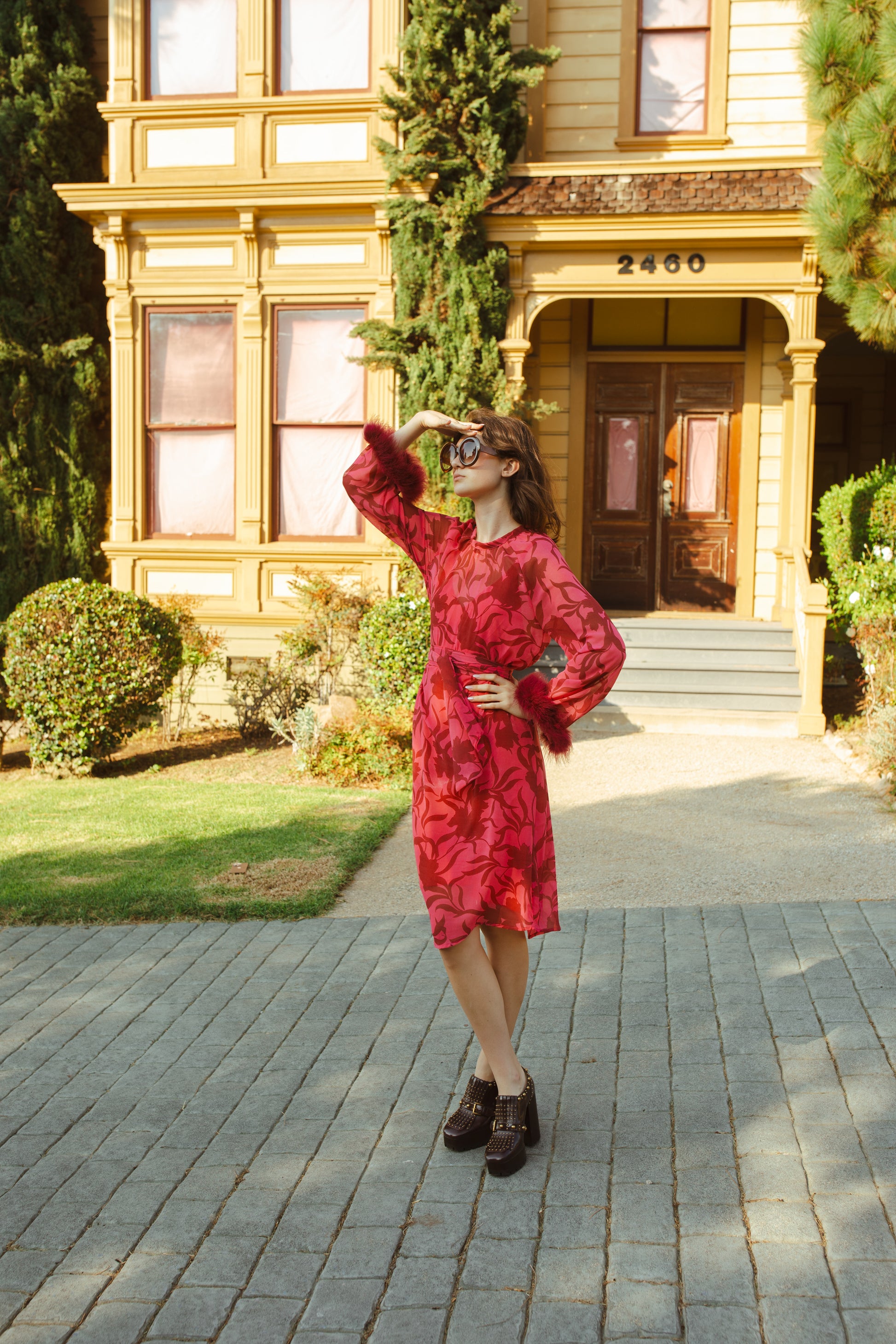 This sophisticated stunner has all the right details - generous bell sleeves with feather detail, flowing knee-length midi skirt, and a slim matching sash for a cinched waist.