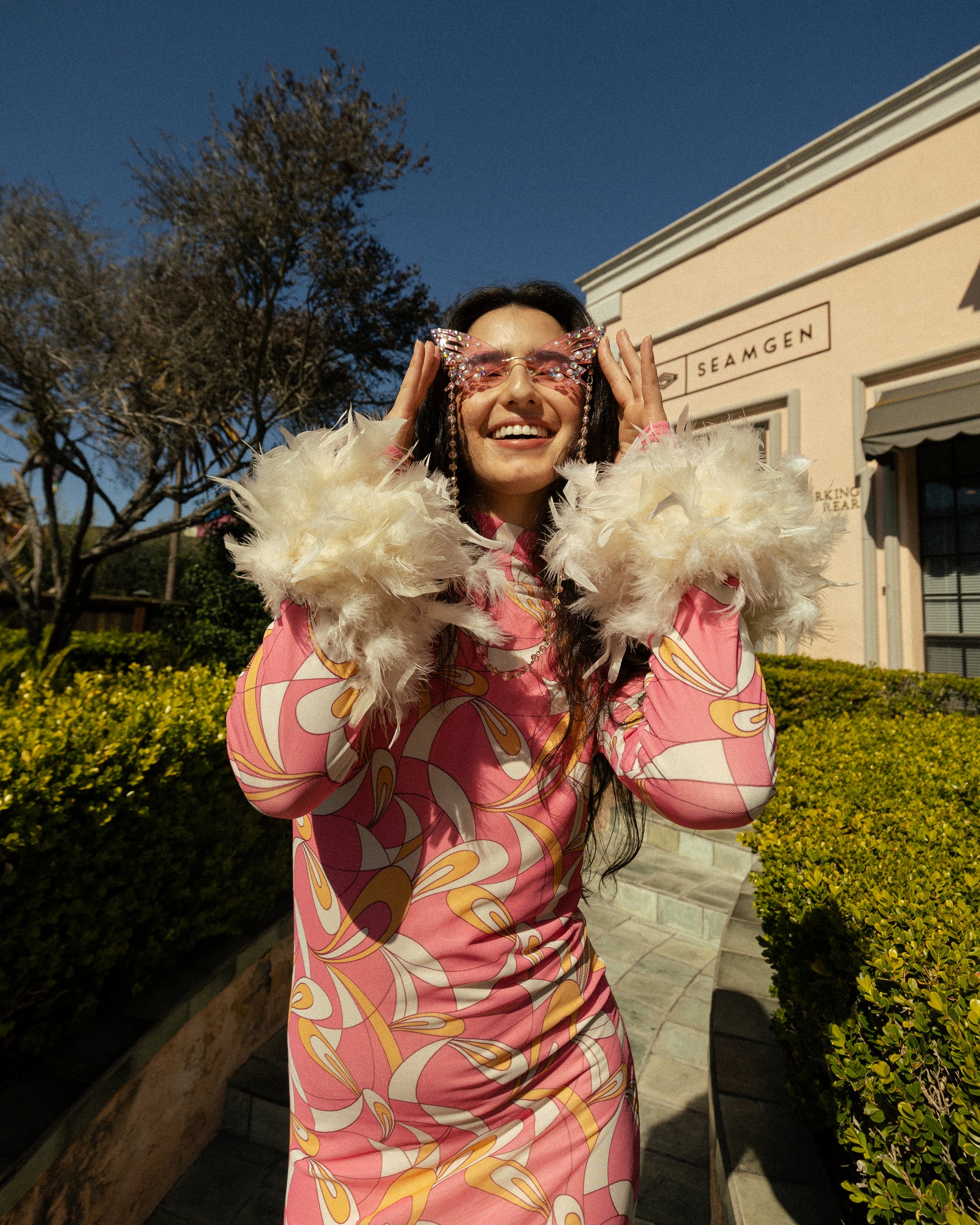 This pop-art bodycon design accentuates your curves, while the removable feather trim on the sleeves adds a touch of elegance.