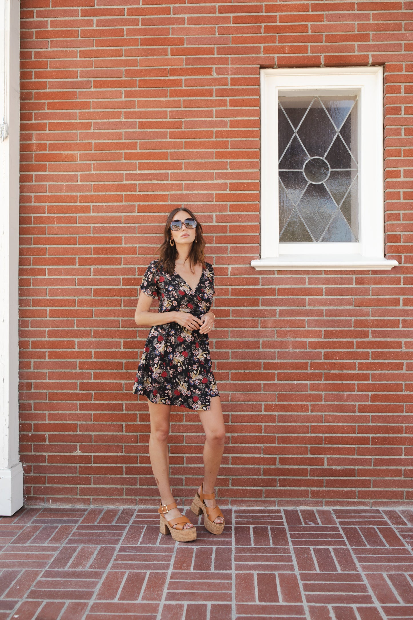 Short-sleeve, v-neck wrap dress. Mini in length, with black base with multicolor vintage-inspired botanical floral flower print. Bohemian summer dress in style.