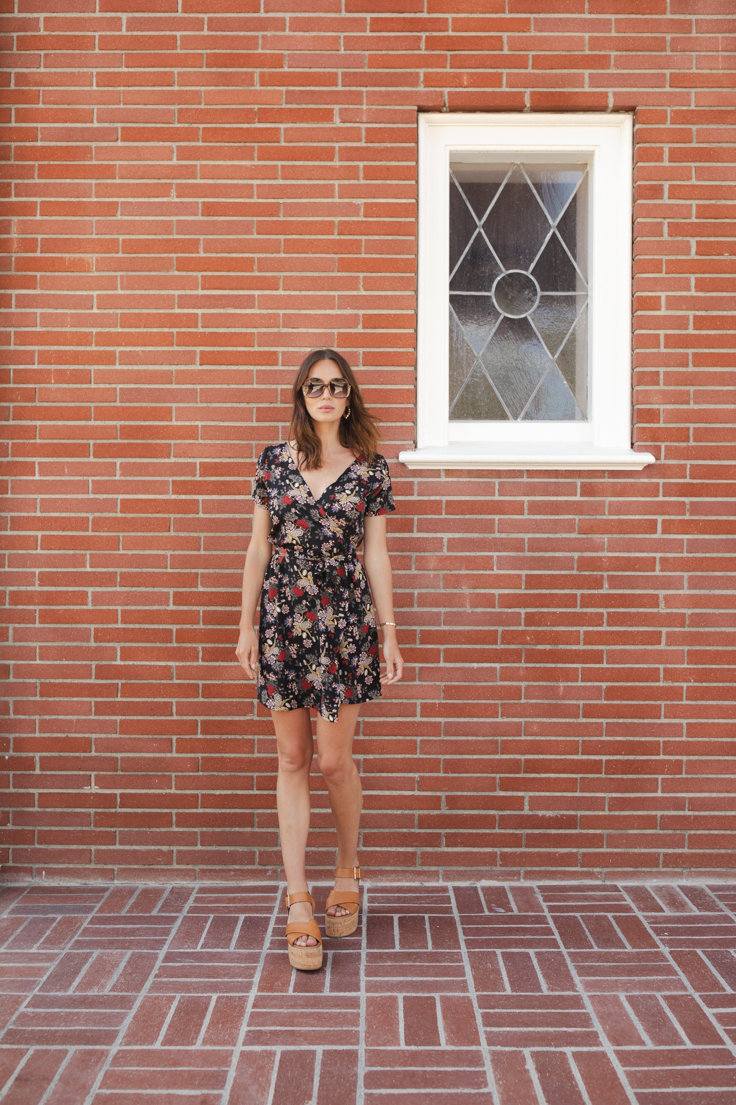 Short-sleeve, v-neck wrap dress. Mini in length, with black base with multicolor vintage-inspired botanical floral flower print. Bohemian summer dress in style.