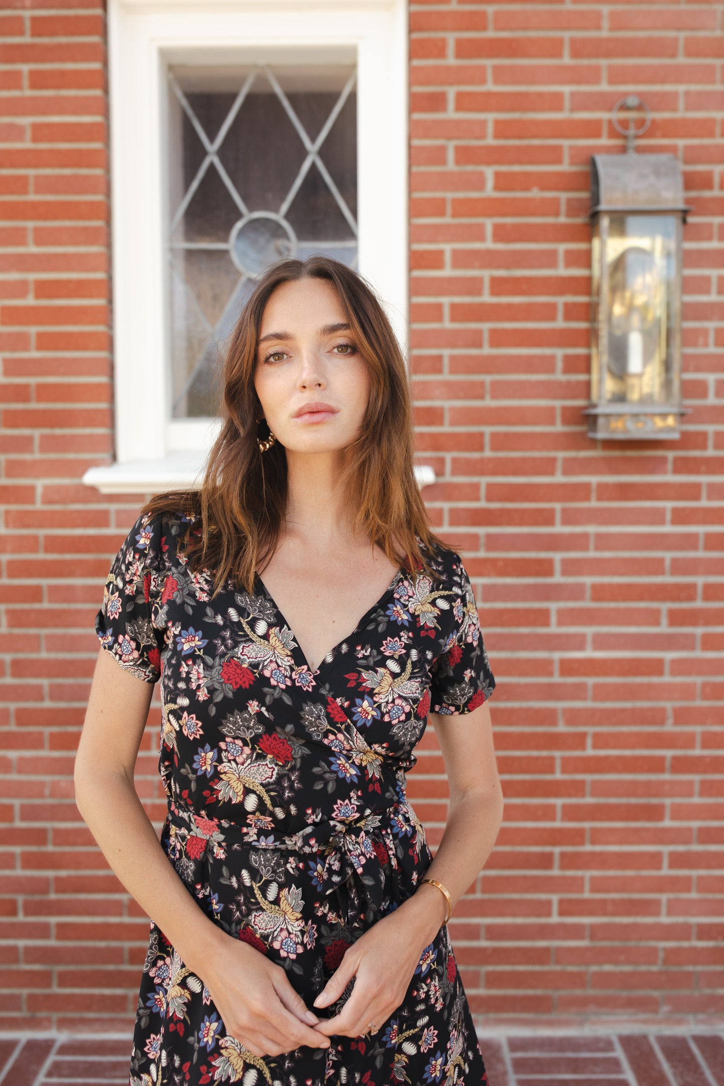 Short-sleeve, v-neck wrap dress. Mini in length, with black base with multicolor vintage-inspired botanical floral flower print. Bohemian summer dress in style.