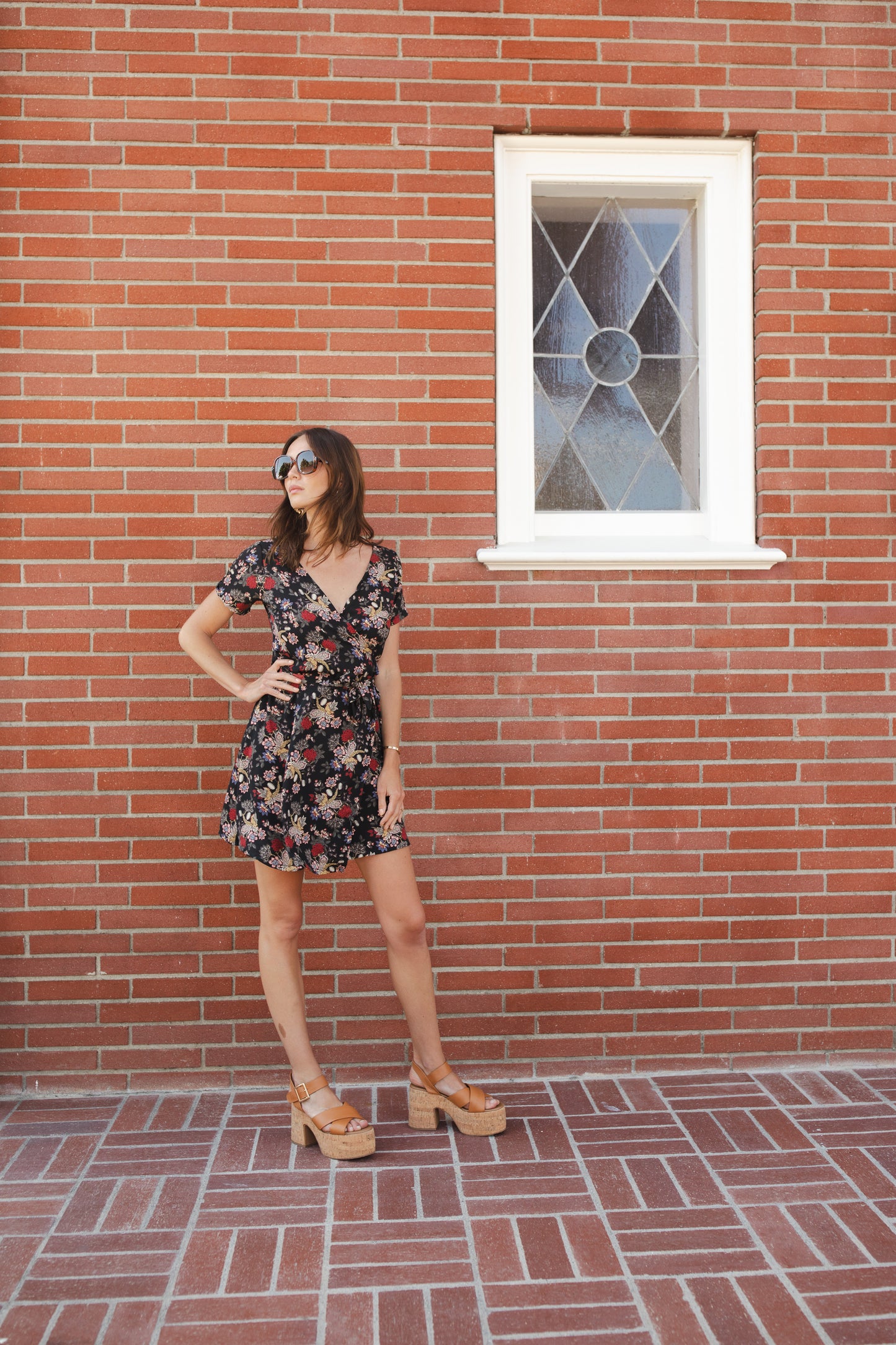 Short-sleeve, v-neck wrap dress. Mini in length, with black base with multicolor vintage-inspired botanical floral flower print. Bohemian summer dress in style.