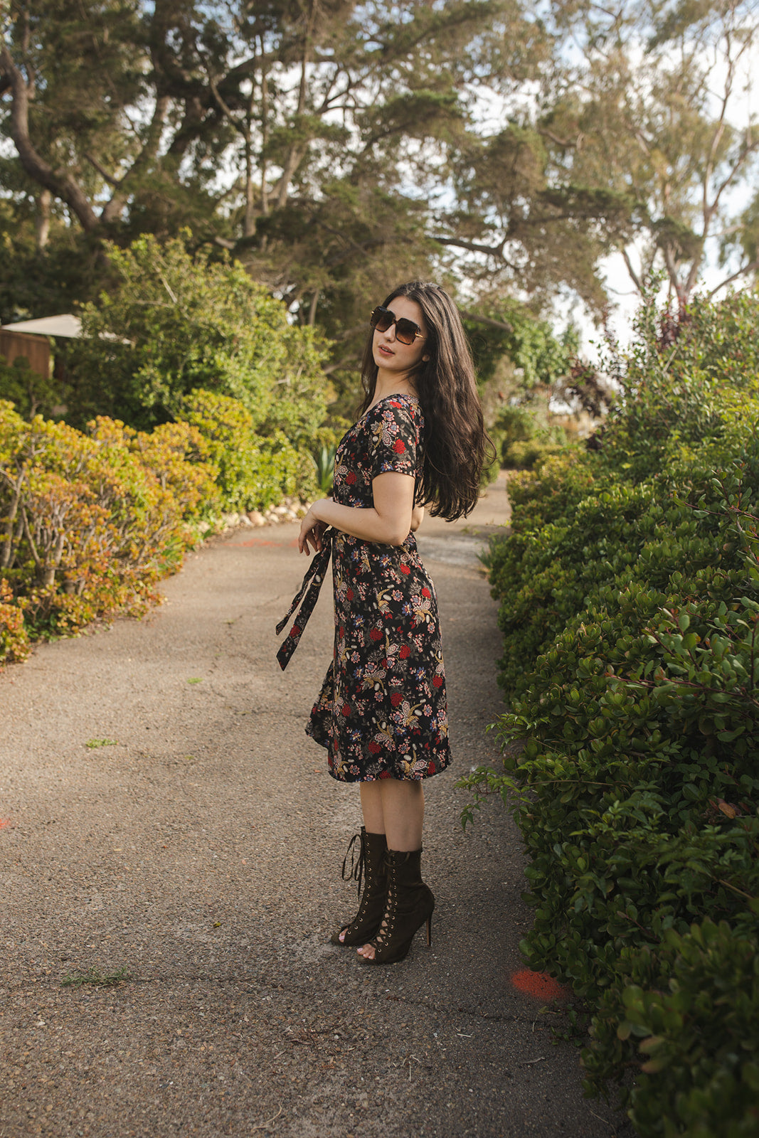 Short-sleeve, v-neck wrap dress. Midi in length, with black base with multicolor vintage-inspired botanical floral flower print. Bohemian summer dress in style.