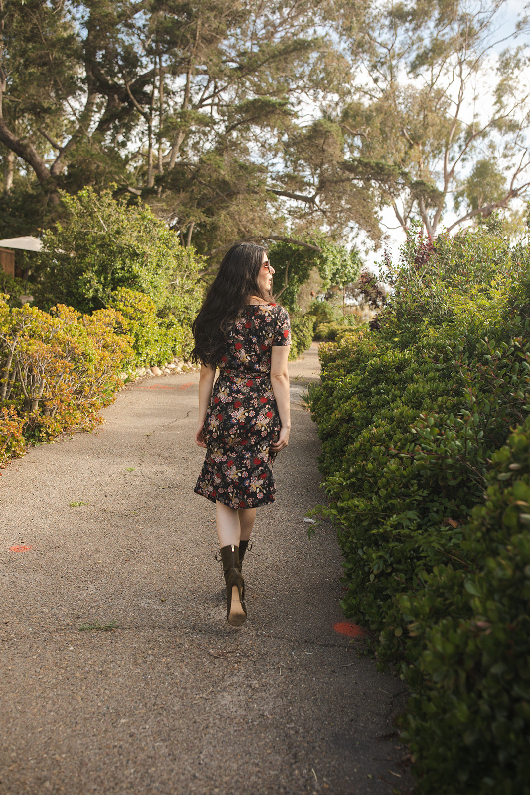 Short-sleeve, v-neck wrap dress. Midi in length, with black base with multicolor vintage-inspired botanical floral flower print. Bohemian summer dress in style.