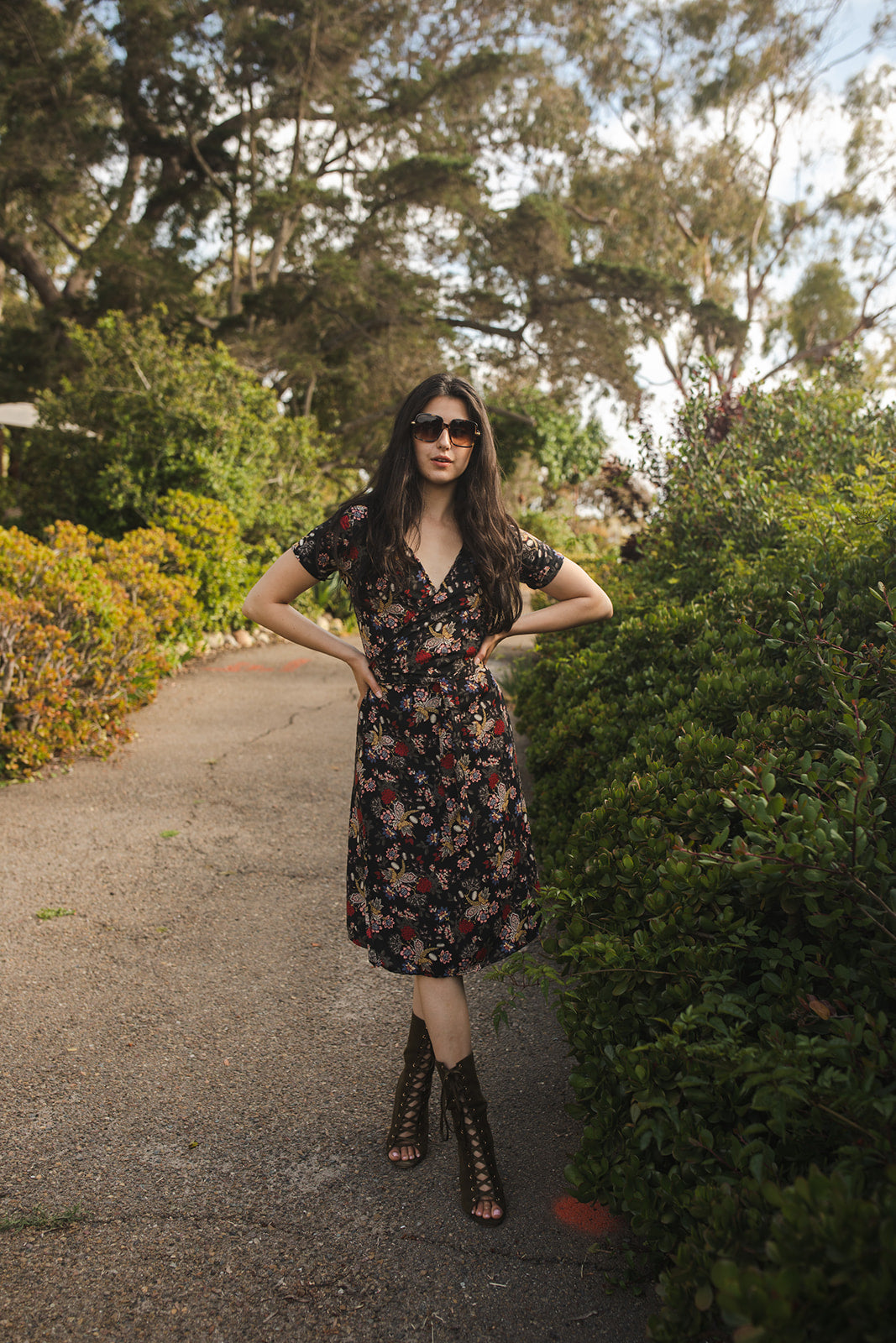 Short-sleeve, v-neck wrap dress. Midi in length, with black base with multicolor vintage-inspired botanical floral flower print. Bohemian summer dress in style.