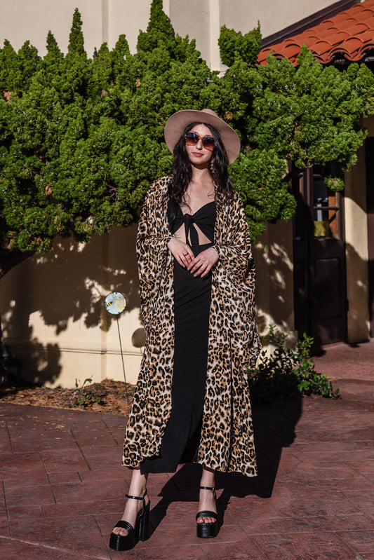 Leopard print fashion kimono robe featuring shades of brown, white, and black. It has a wrap tie waist for a cinched look, v-neck, square sleeves, and an ankle length hem. Classic, bohemian retro aesthetic.