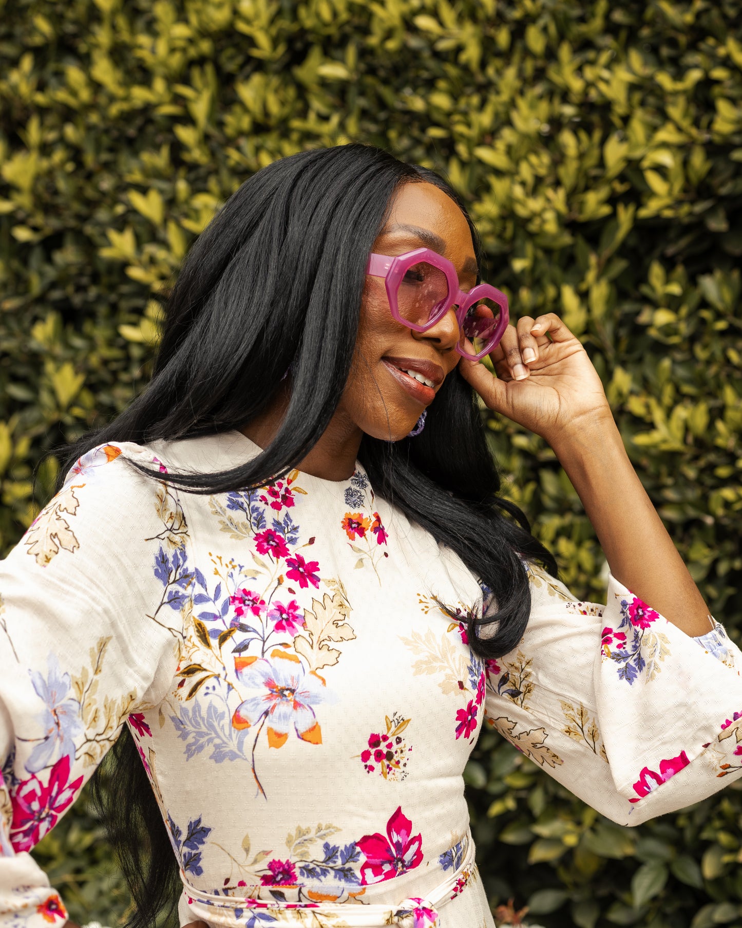 A floral maxi dress made from a soft, linen like crepe, it features high neck, bishop sleeves, tiered ruffle skirt and matching sash for a cinched waist. It's light, airy silhouette. Base color is pale yellow with a mixture of fuchsia, orange, and blue flowers as the print.