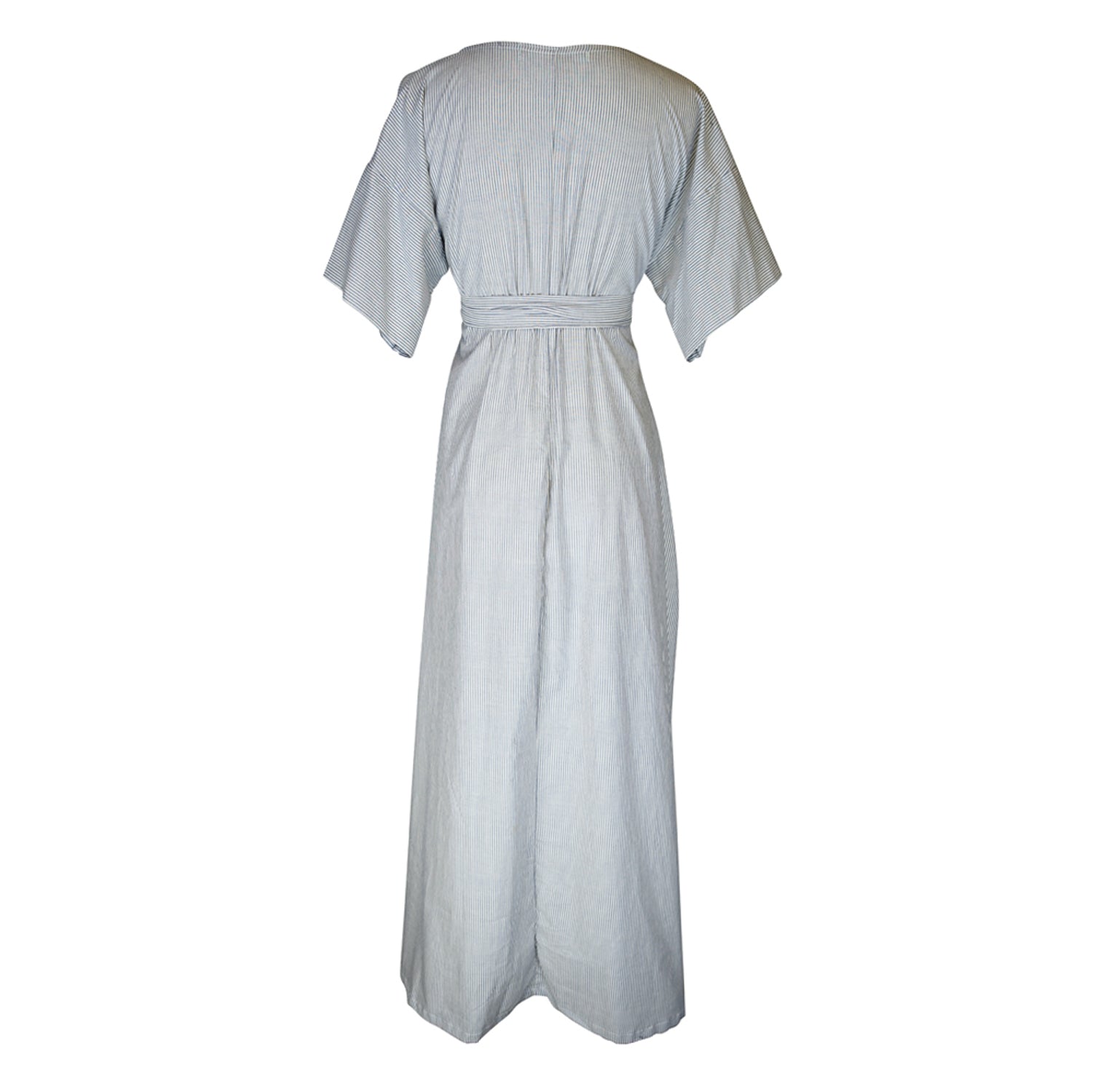 White and blue vertical pinstripe a-line midi-maxi dress featuring v-neck, short sleeves, and built-in sash ties for a cinched, wrap waist look. This dress falls at approximately lower calf or ankle. Nautical bohemian in style.