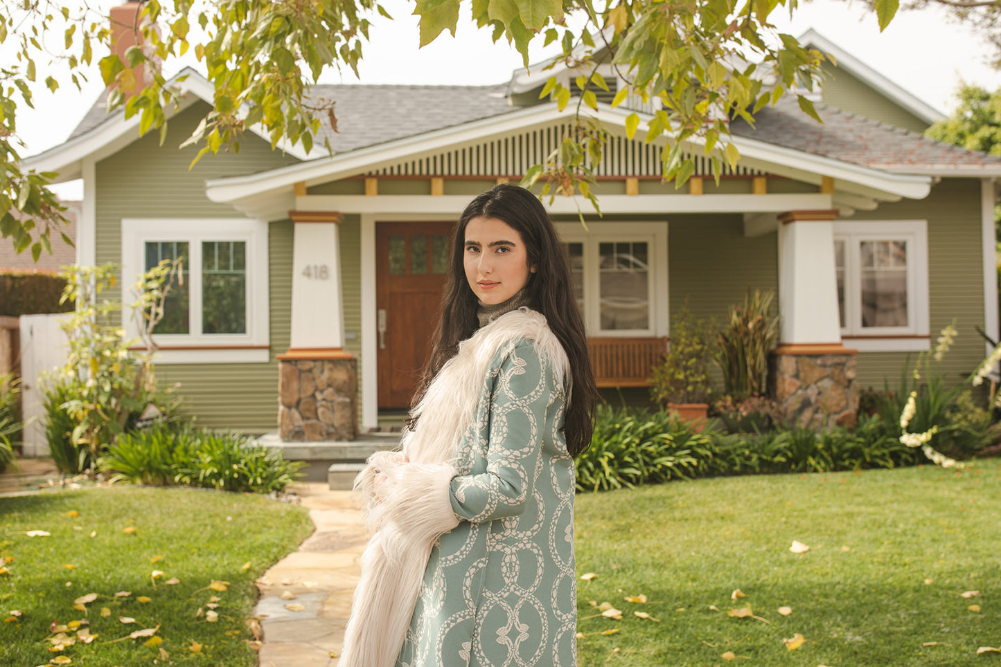 Long, penny lane style trench coat fashioned from a thick, mint green fabric embroidered with ivory snakes. Embellished with long ivory faux fur along collar, lapel, cuffs, and hem. Bohemian maximalism in style.