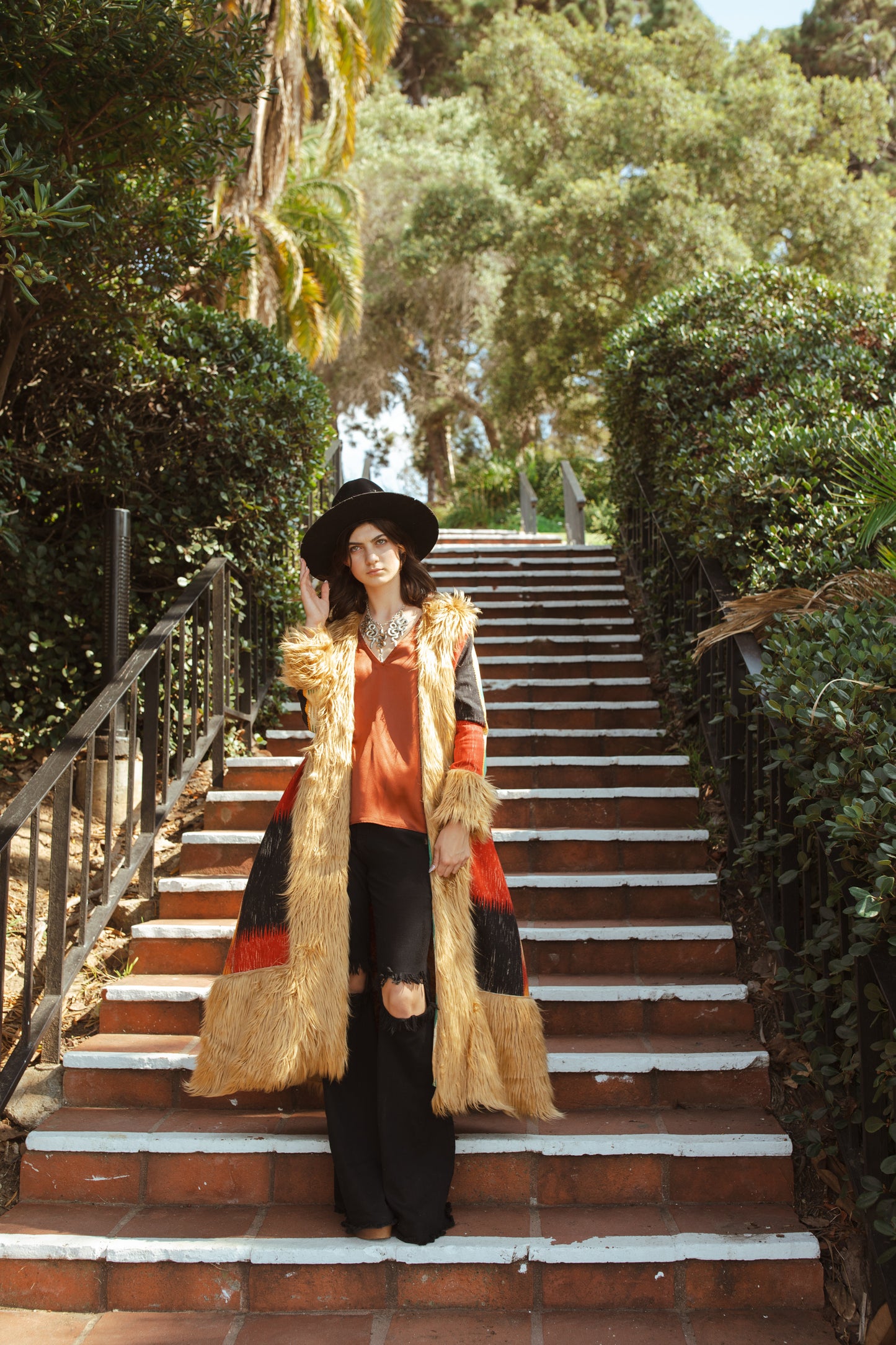 Long, penny lane style trench coat fashioned from a thick, abstract modernist colorblock print fabric featuring red, teal, yellow, black, and beige. Embellished with long tan faux fur along collar, lapel, cuffs, and hem. Retro bohemian color field art in style.