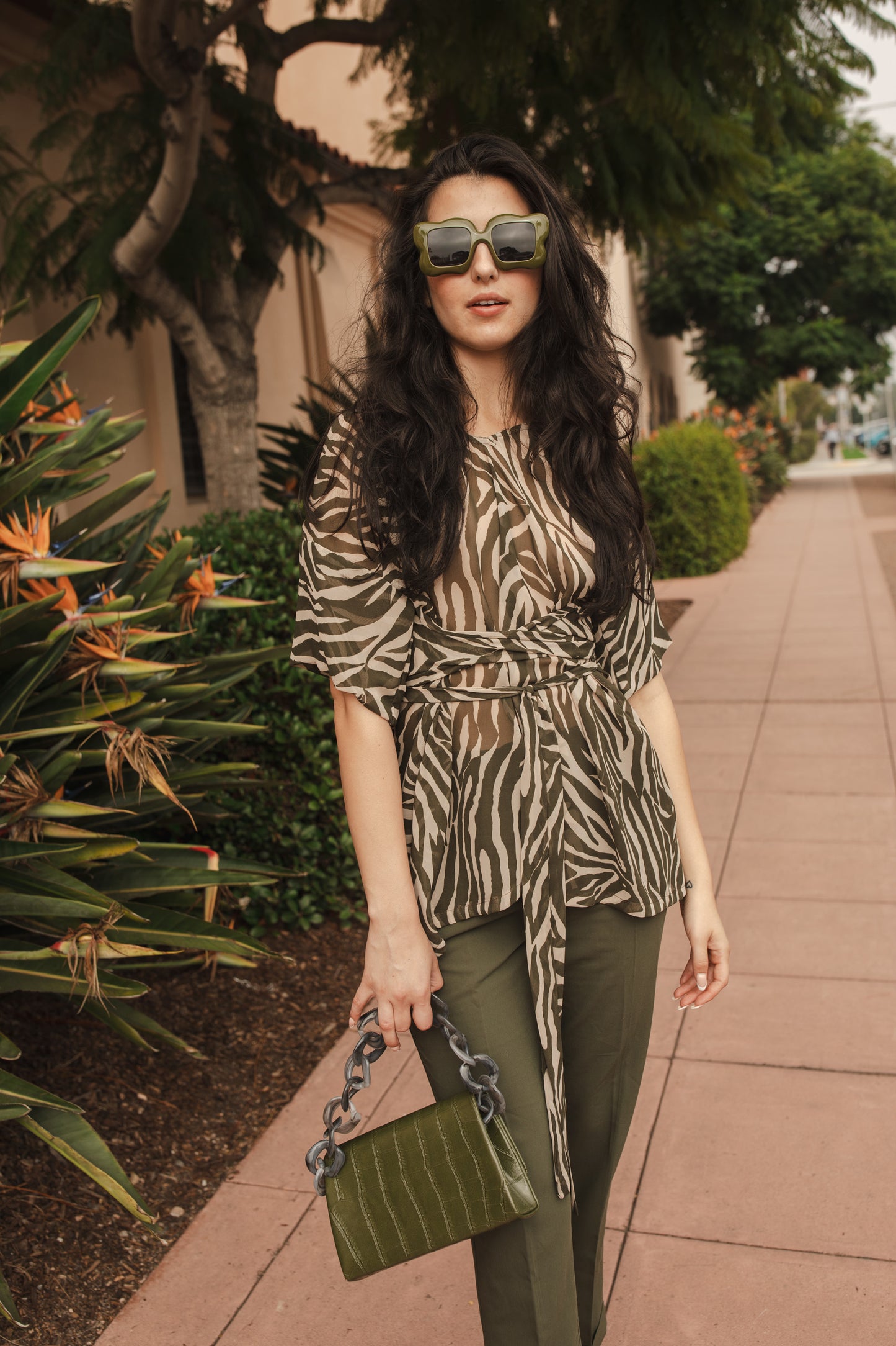 Tunic top with large flowy short sleeves and wide short v-neck. Featuring an olive green zebra print in semi-sheer chiffon with matching waist tie.