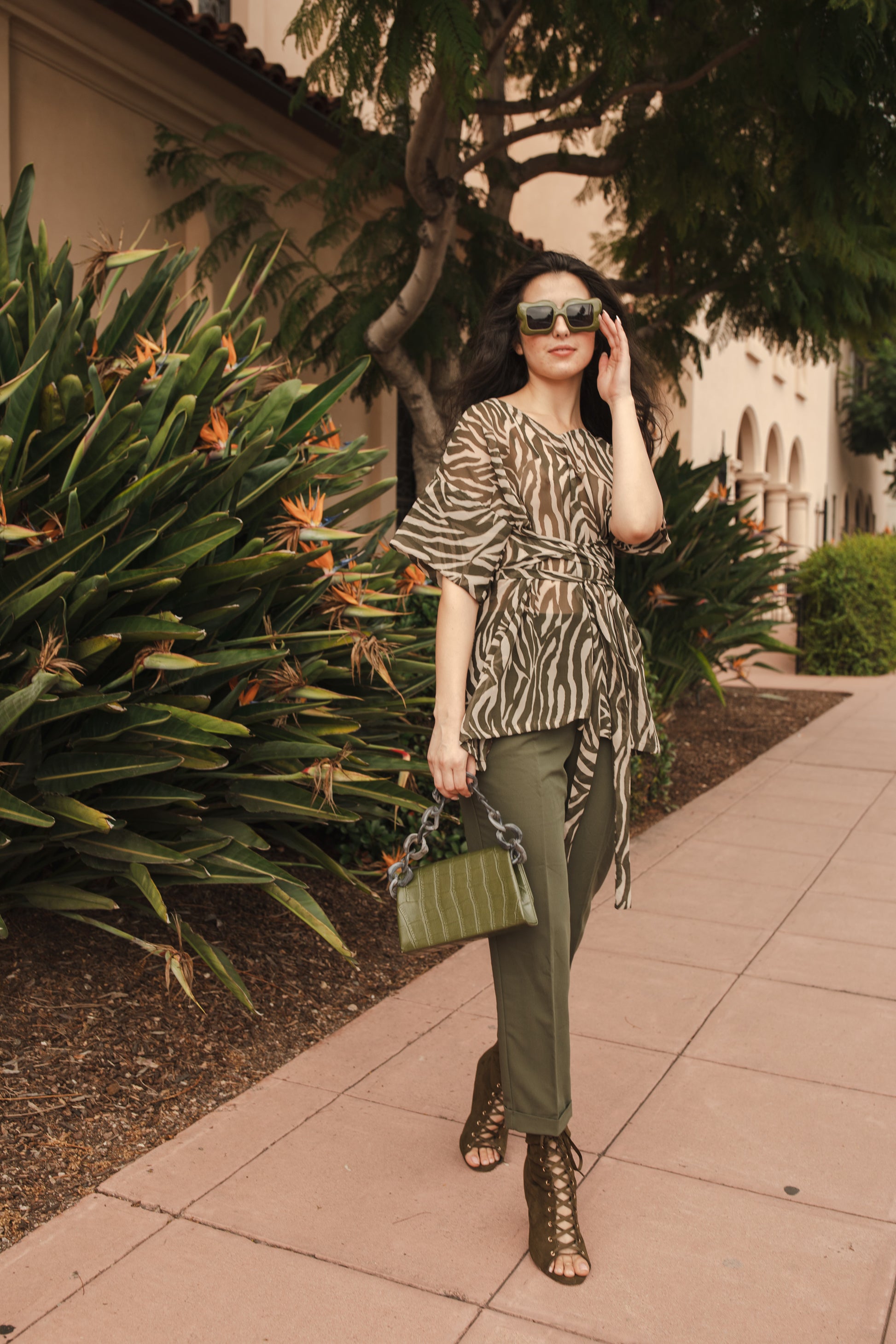 Tunic top with large flowy short sleeves and wide short v-neck. Featuring an olive green zebra print in semi-sheer chiffon with matching waist tie.