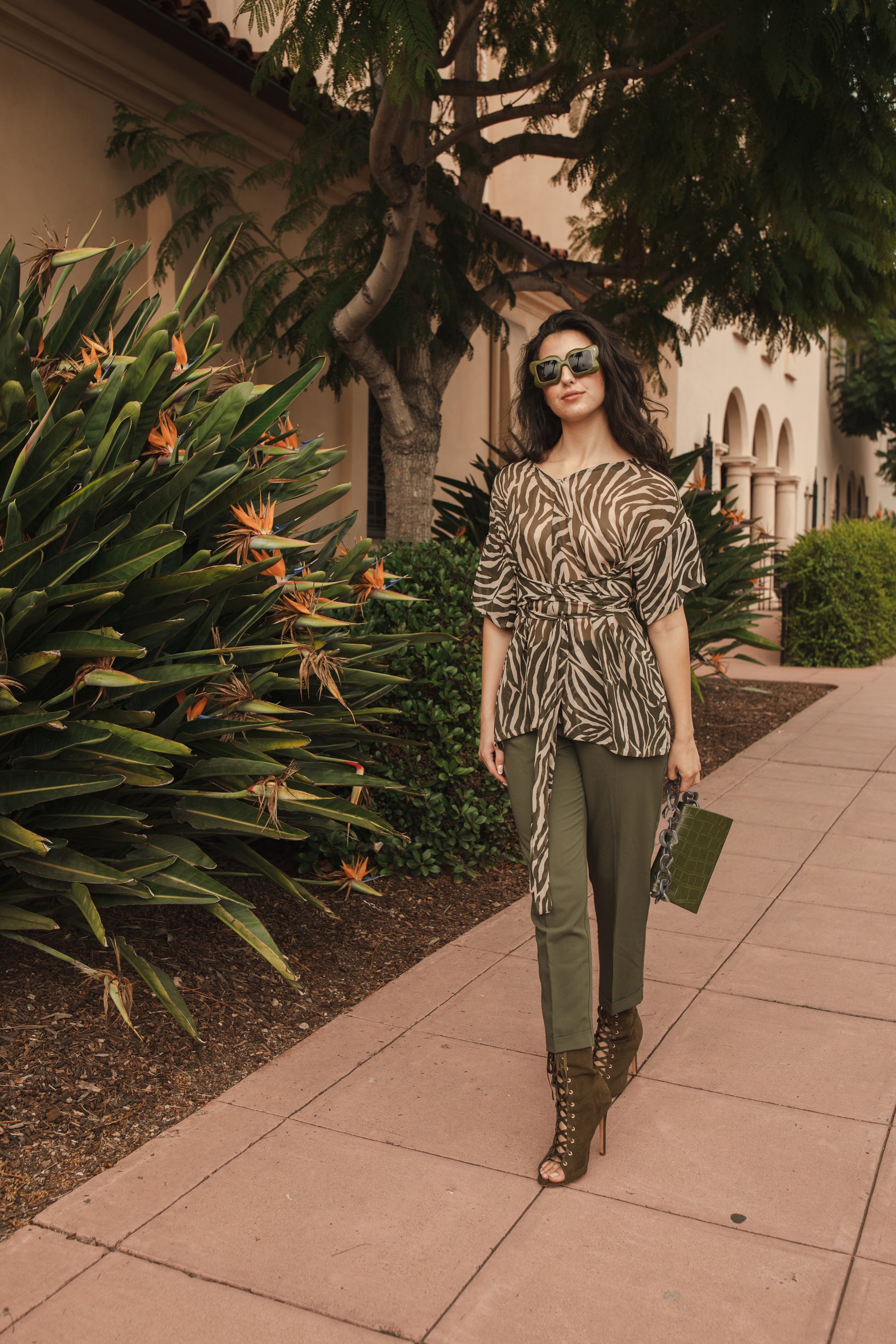 Tunic top with large flowy short sleeves and wide short v-neck. Featuring an olive green zebra print in semi-sheer chiffon with matching waist tie.