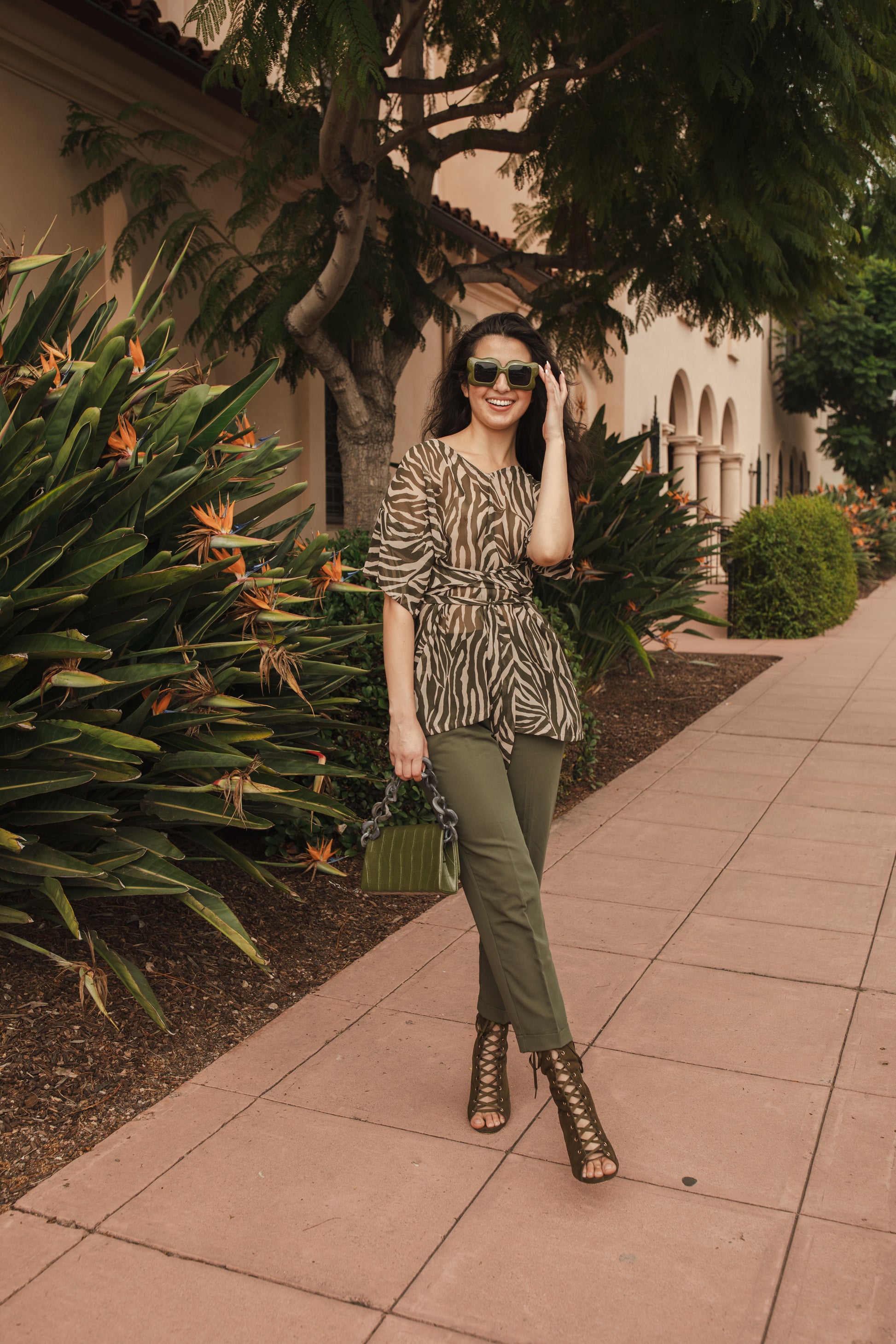 Tunic top with large flowy short sleeves and wide short v-neck. Featuring an olive green zebra print in semi-sheer chiffon with matching waist tie.
