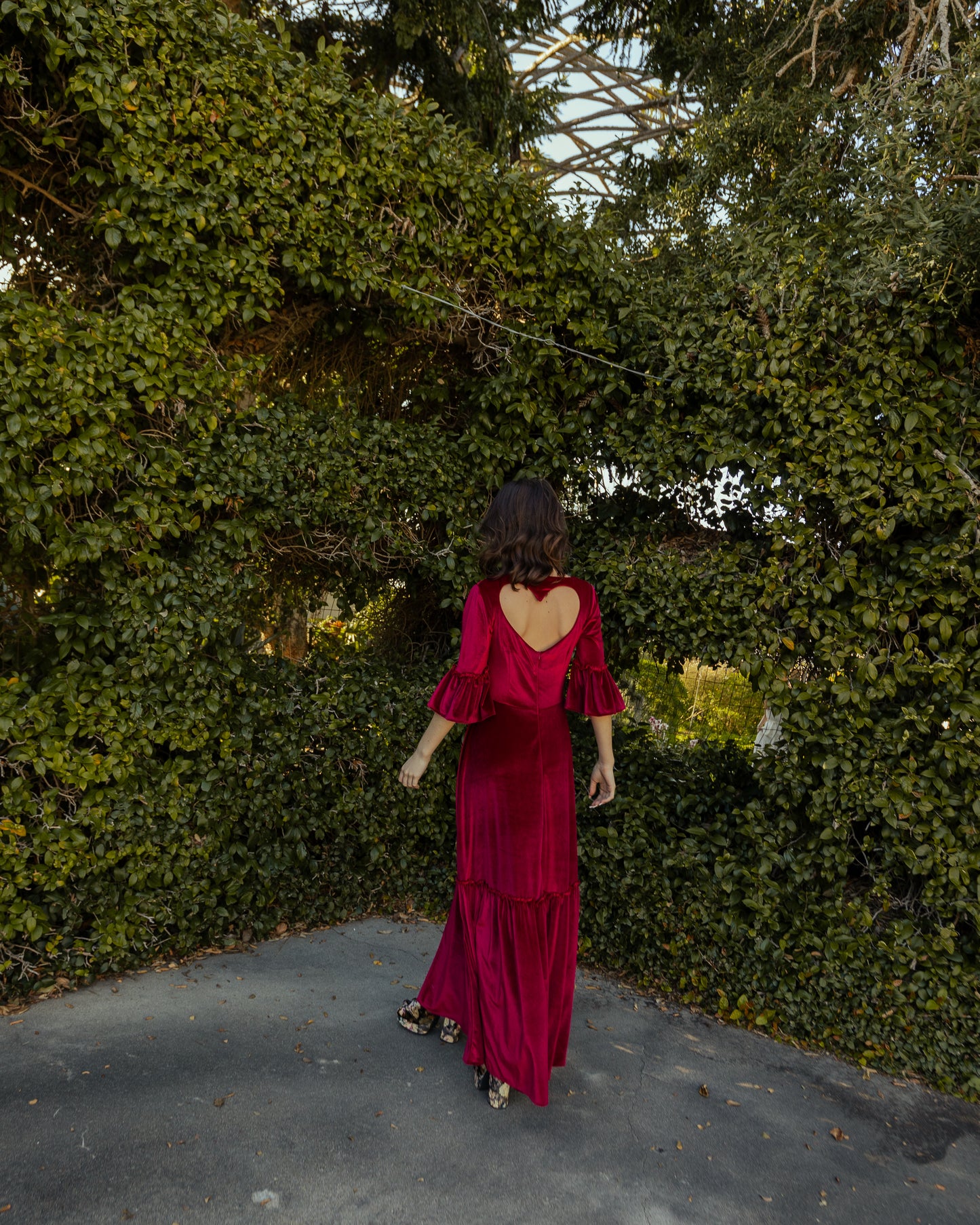 This deep red velvet sweetheart dress features bell sleeves and a full tiered ruffle skirt. With an optional sweetheart cut out in back, you can show off a little skin while still concealing your bra.
